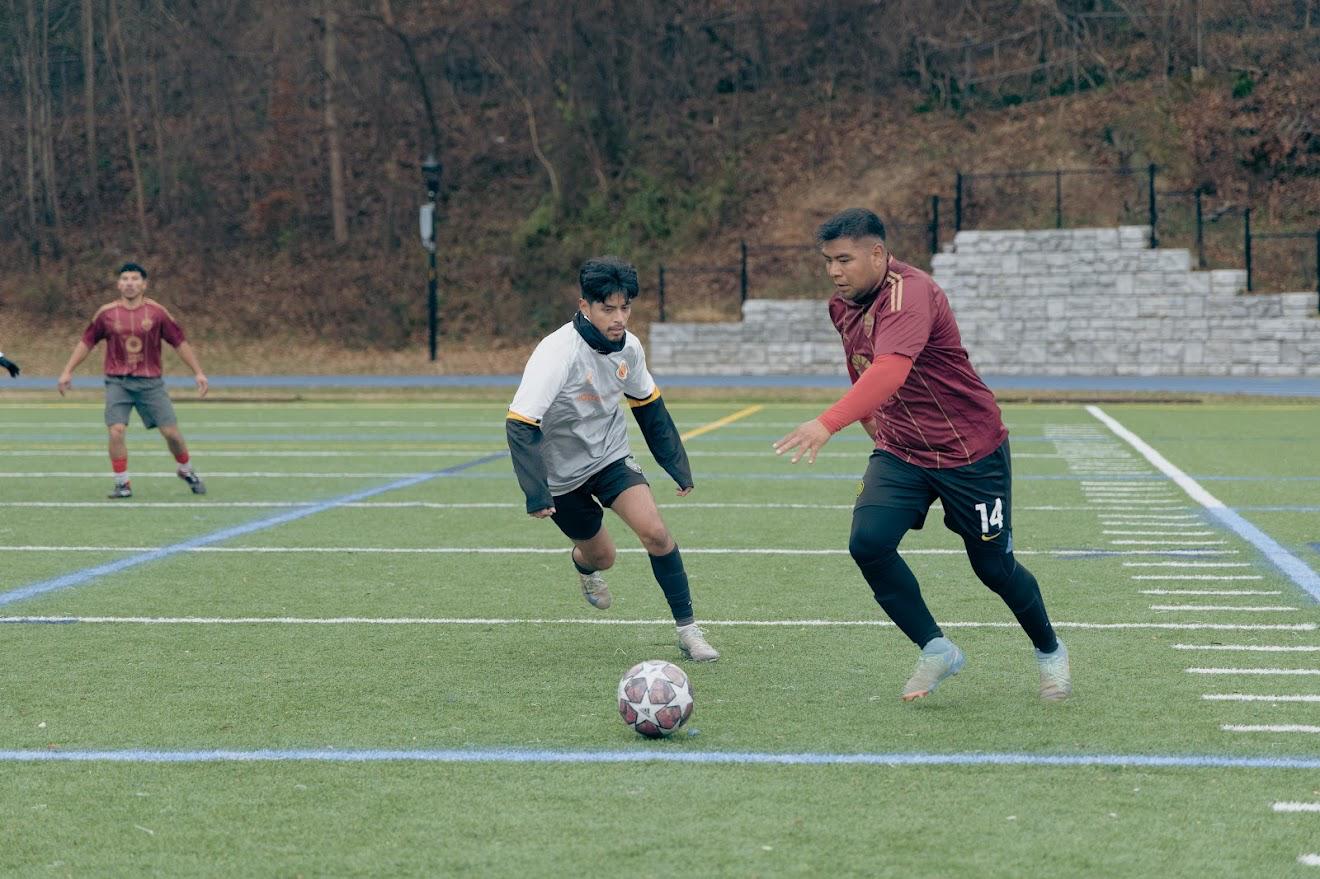 man in gray hoodie and blue denim jeans standing on brown wooden parquet flooring