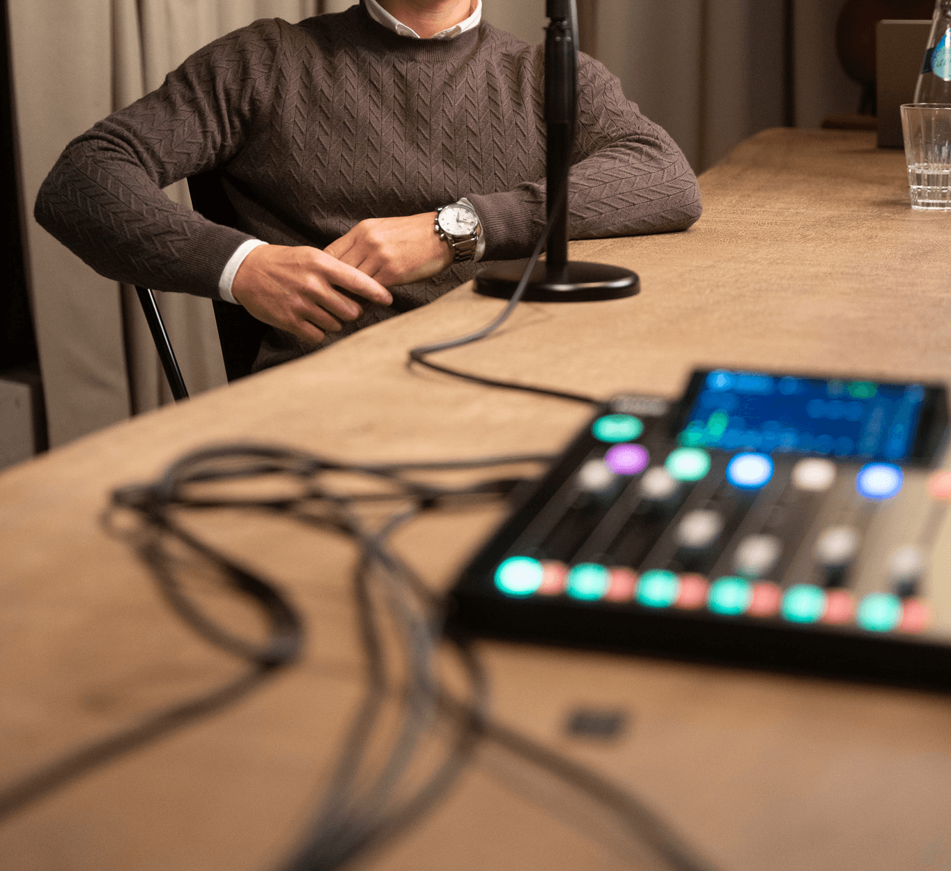 Two men sitting at a table holding a podcast