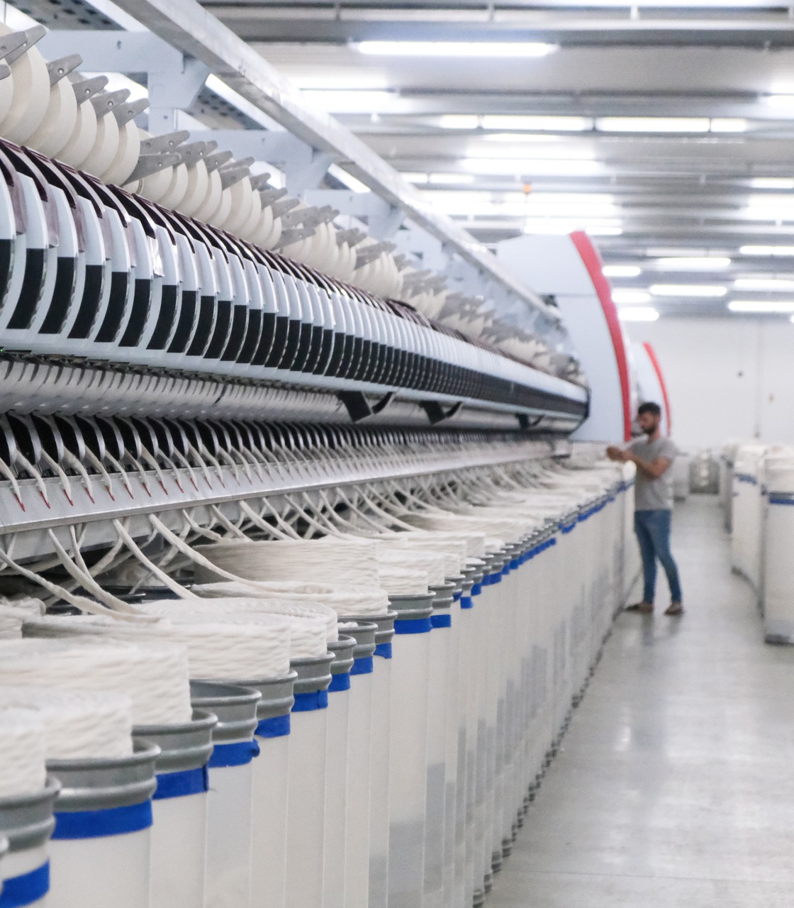 Industrial textile production line with automated spinning machines and yarn processing