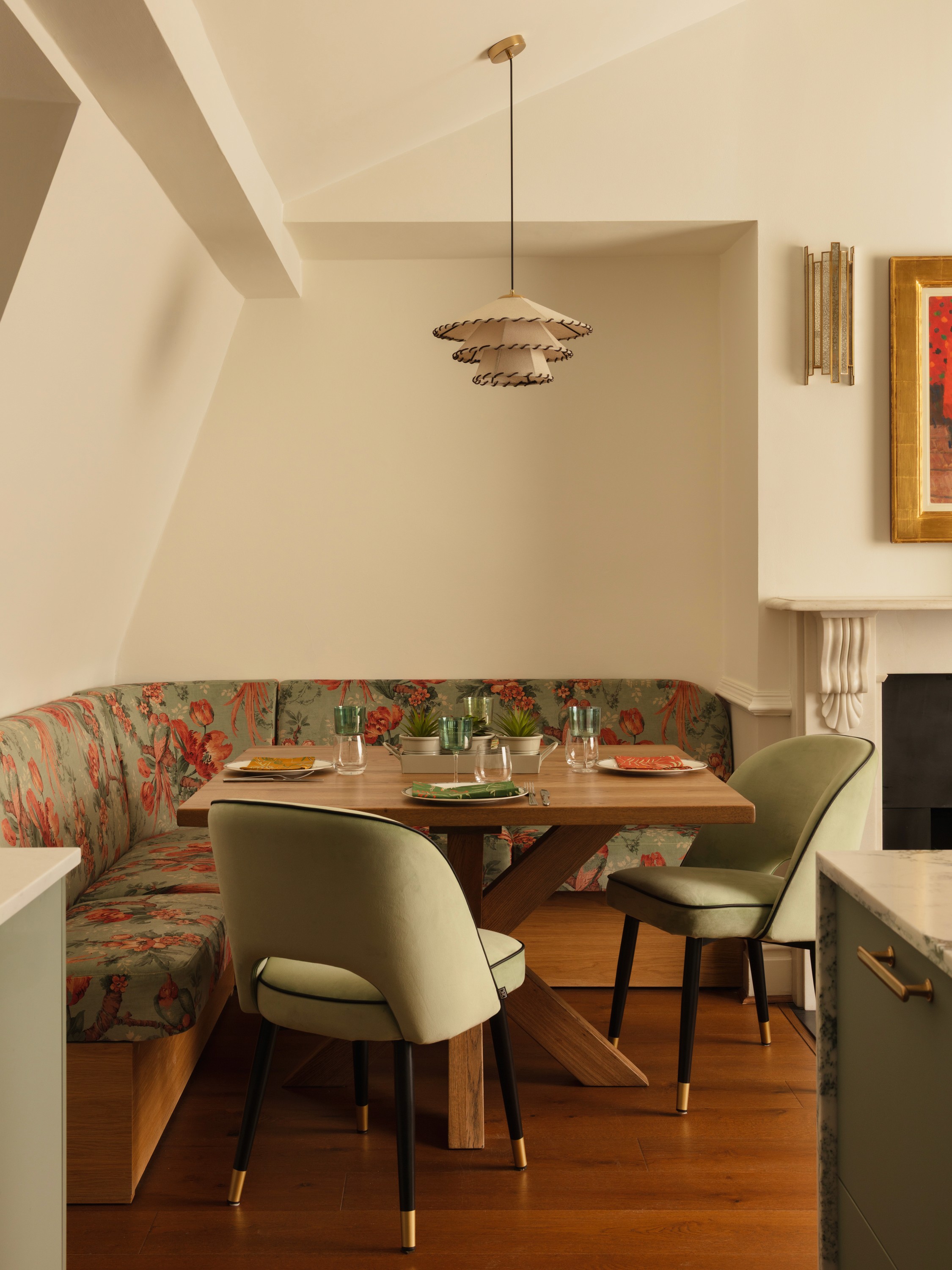 A restaurant interior featuring marble countertops, brown leather chairs, wood-paneled walls, and round pendant lights hanging above a bar set with wine glasses.