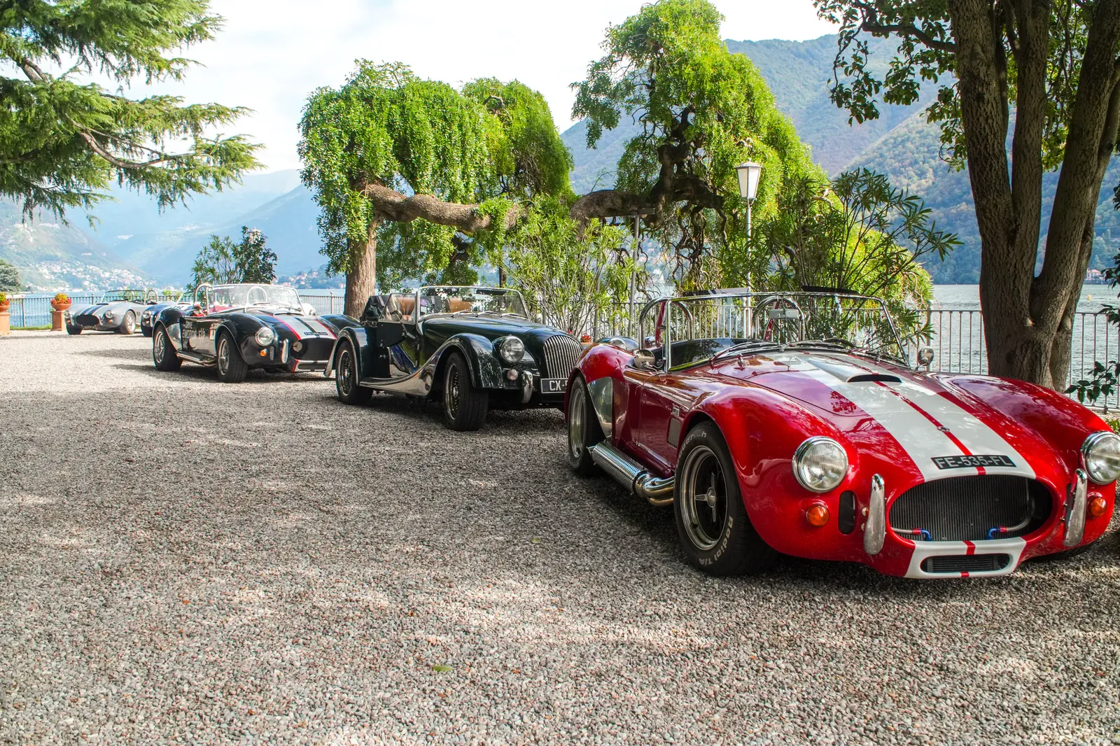 AC Cobra rouge et Morgan garées au bord d'un lac italien