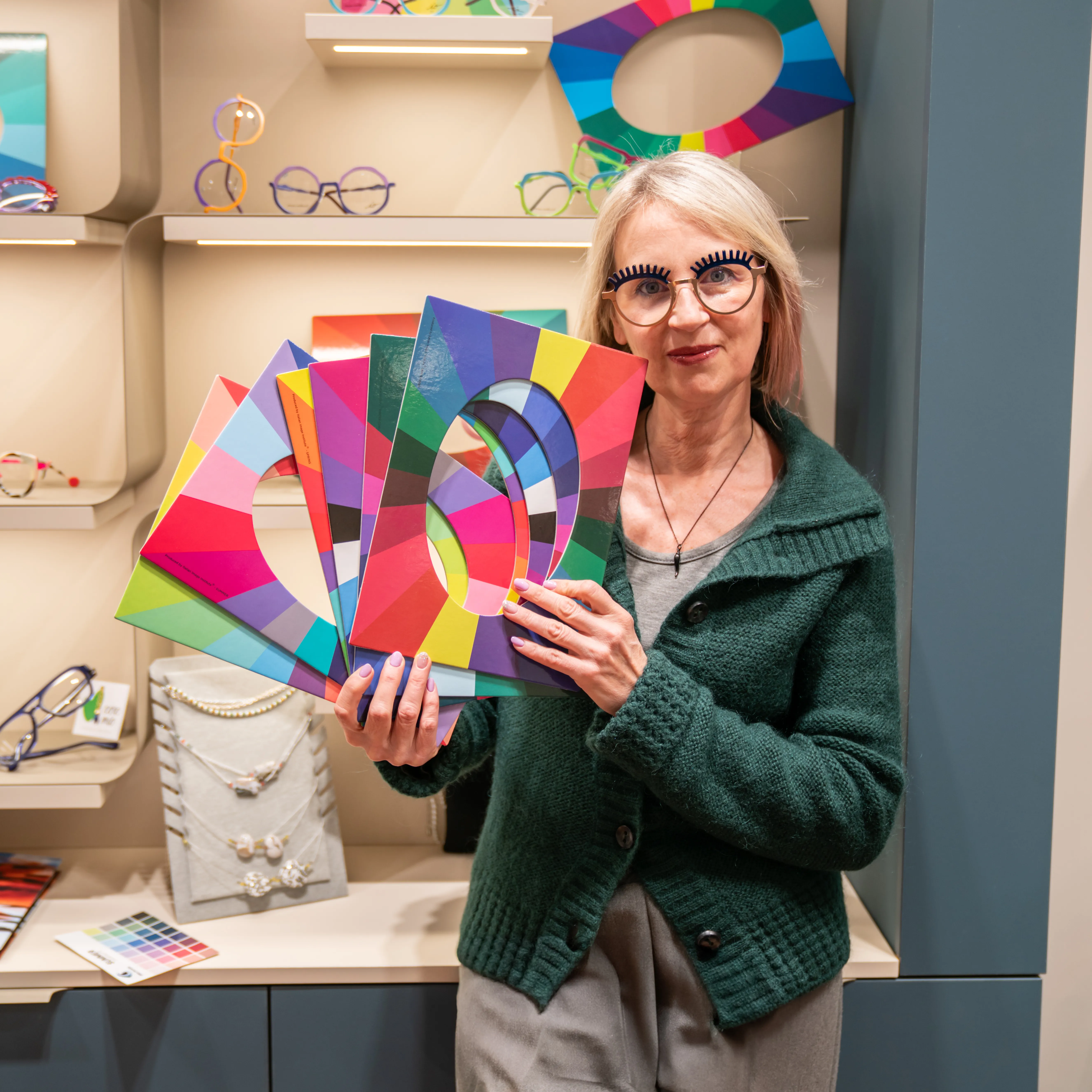 Cristina Notarangelo di Ottica Dentella ad Ancona mostra una selezione di palette e campioni colore utilizzati durante l’analisi armocromatica per la scelta degli occhiali. Attraverso lo studio dei colori naturali di incarnato, occhi e capelli, la consulenza di armocromia permette di individuare le tonalità di montature e lenti più armoniose con la persona, valorizzando il viso e guidando verso una scelta dell’occhiale più consapevole, personalizzata e coerente con i propri colori.