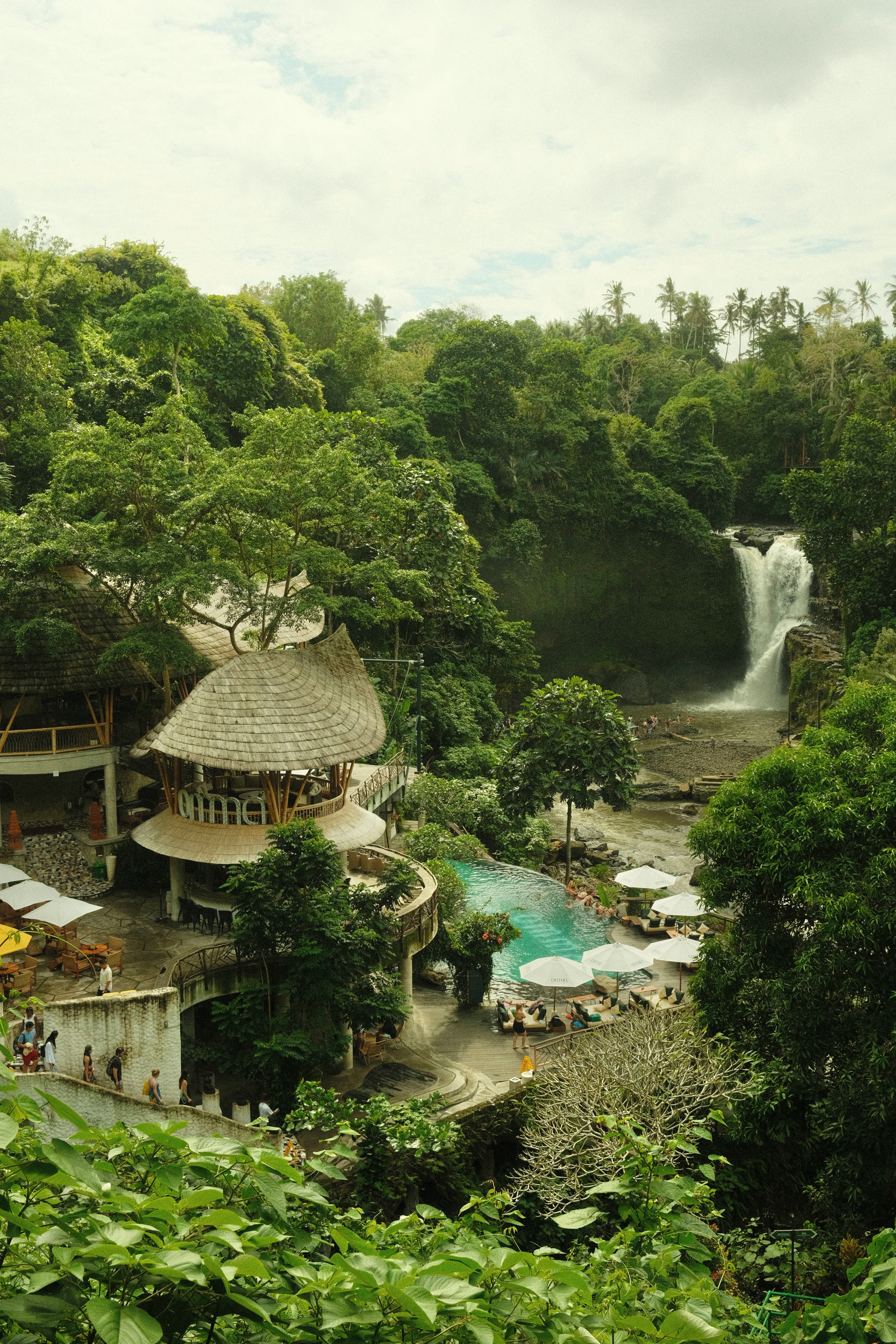 a building with a waterfall and trees around it