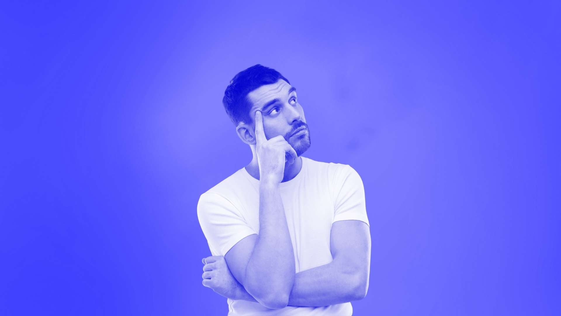 A man standing up thinking with one arm folded