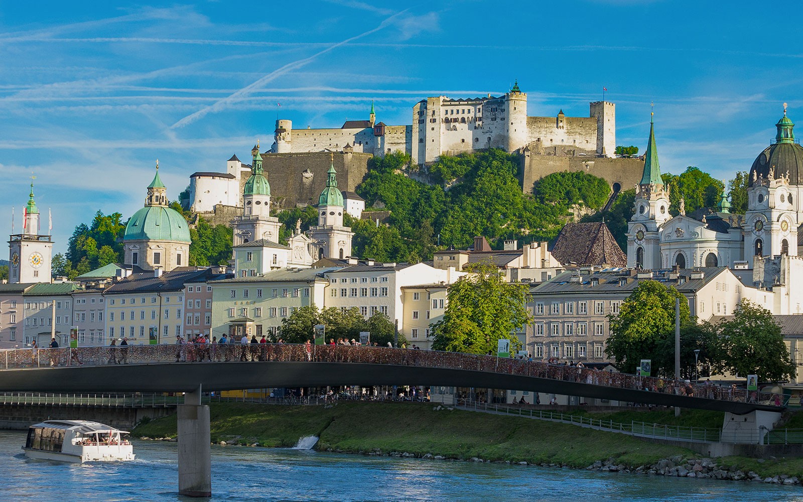在萨尔茨堡俯瞰的霍亨萨尔茨堡要塞,前景中有一艘河流游船。