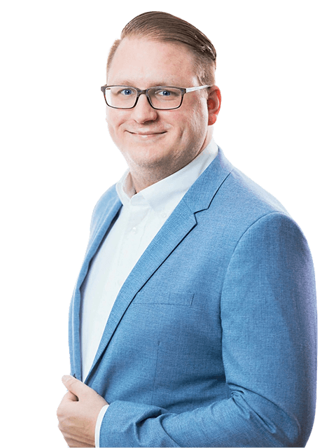 A well-dressed individual in a blue blazer poses confidently with a slight smile against a neutral background.