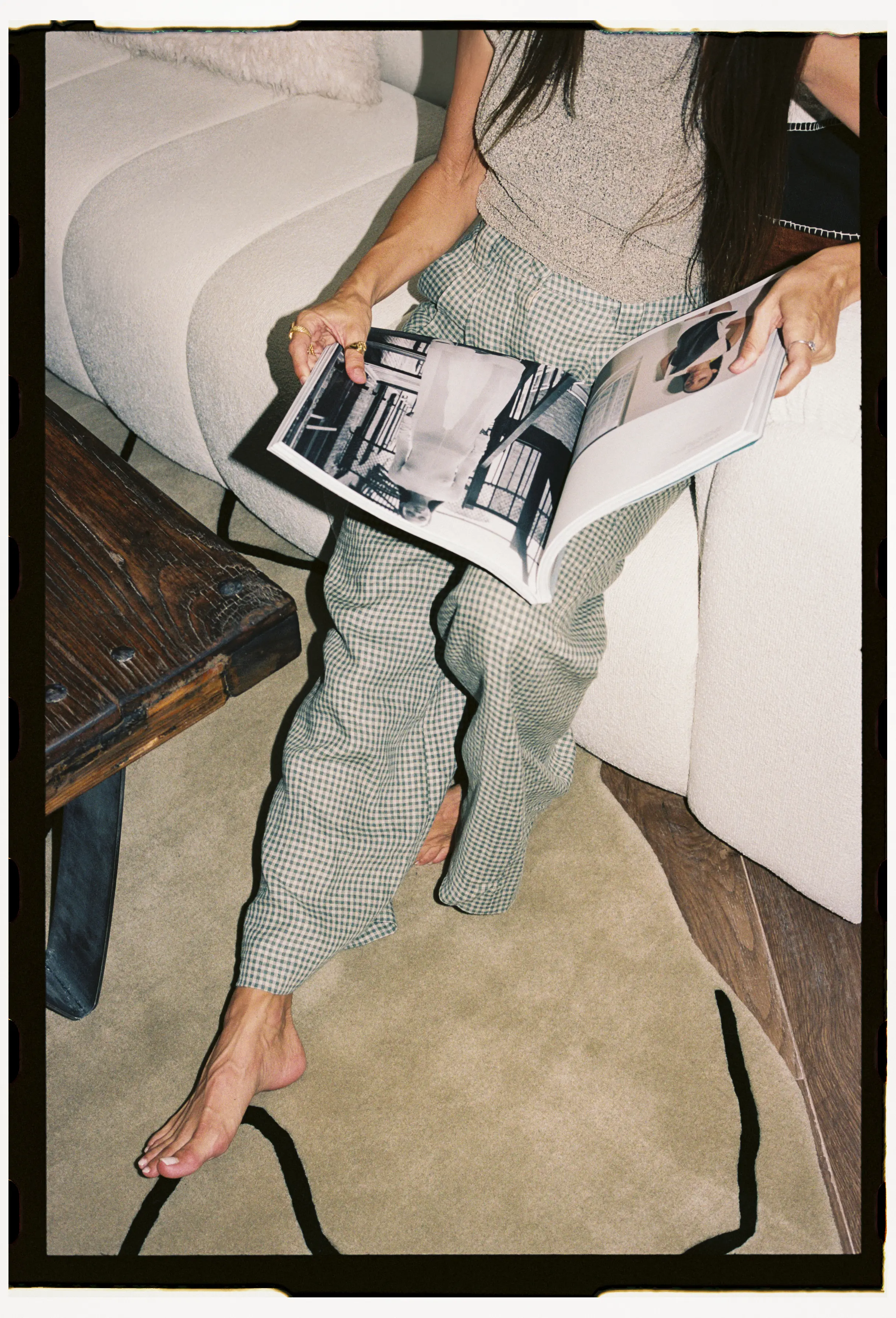 chica sentada en sofa costeniendo un catalogo