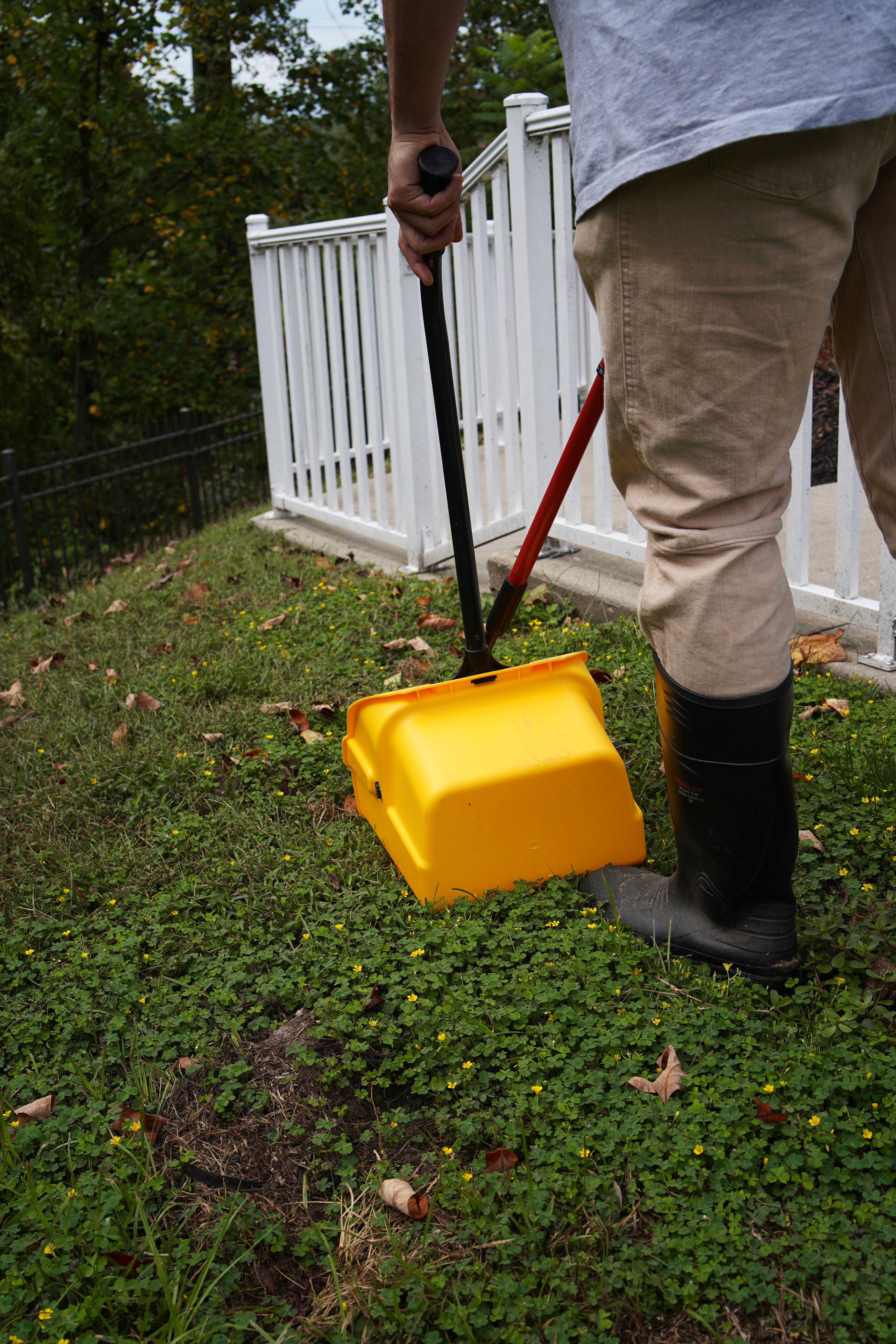 Worker outside holding 'Dime & Scoop' bucket in front of face.