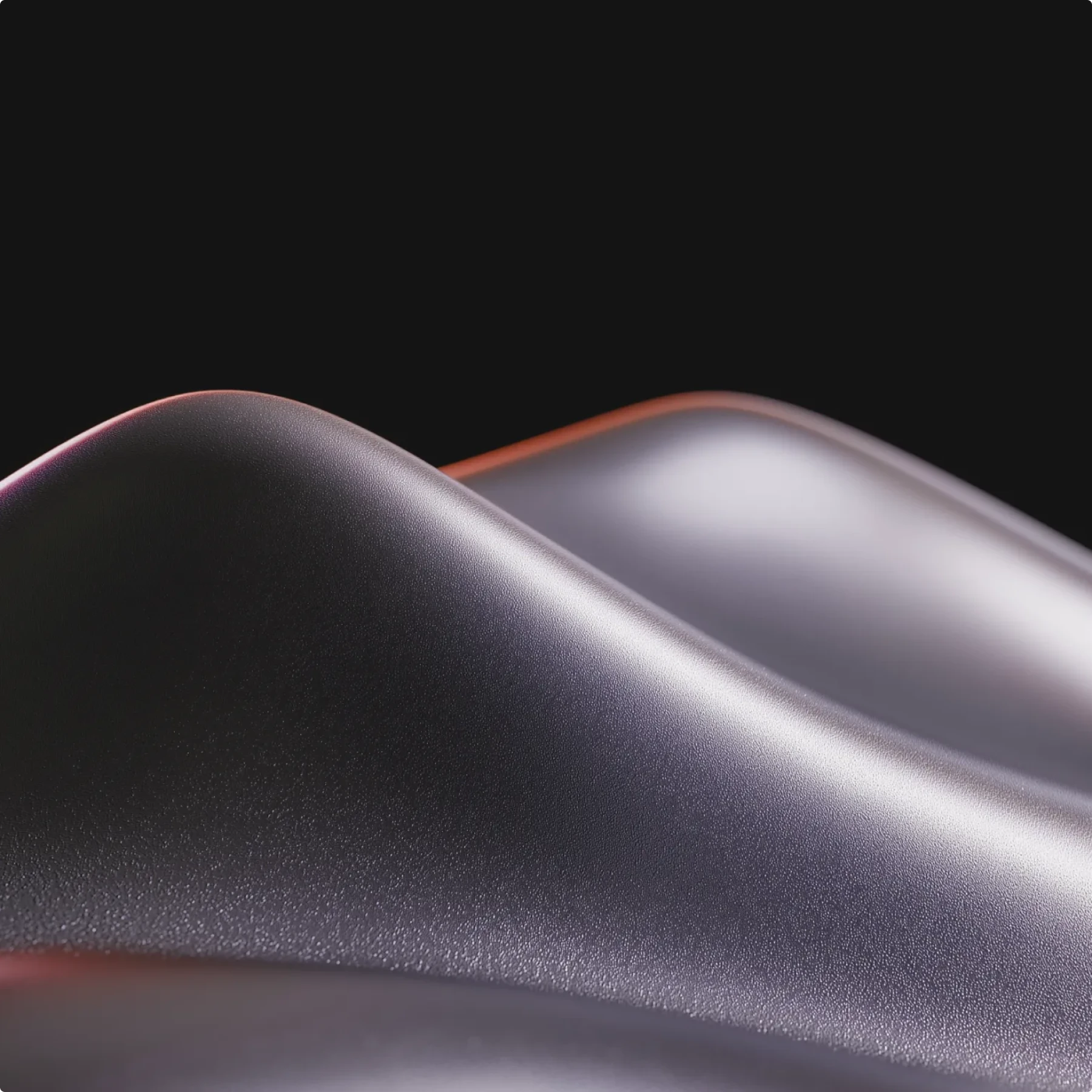 Smooth metallic surface with curved folds against a black background.