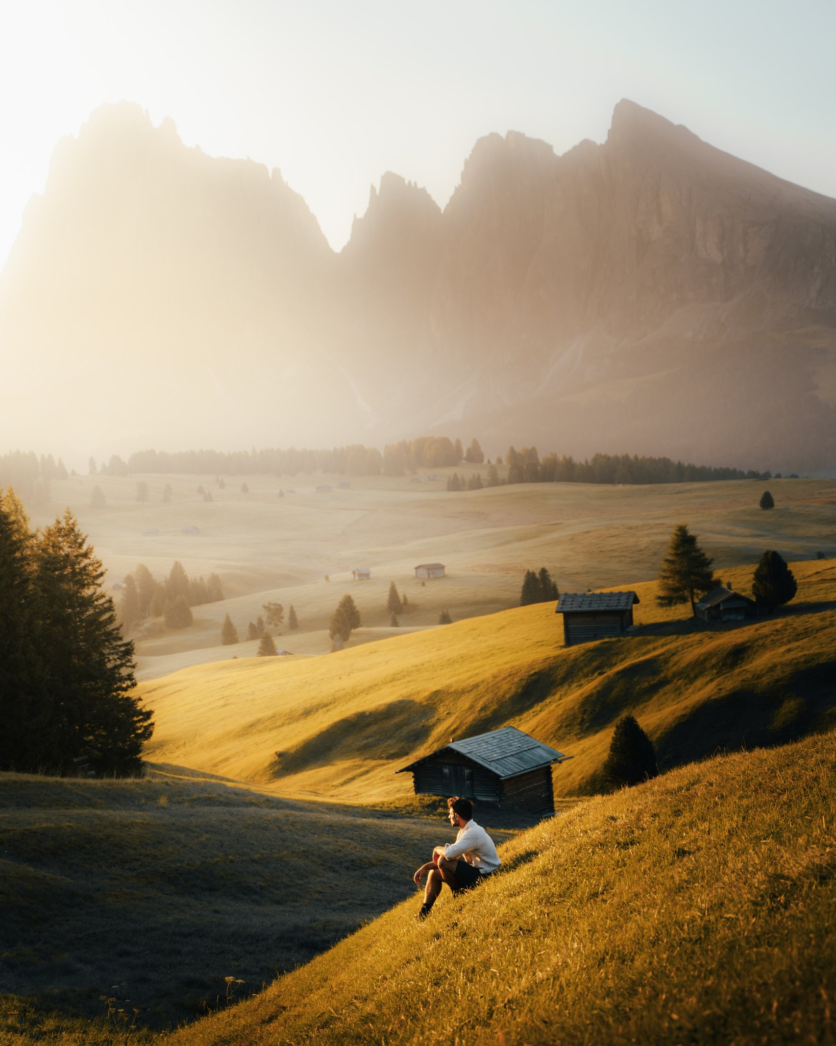 A person in a red turtleneck and round red sunglasses stands against a matching red background. The mood is bold and stylish, with vibrant red tones.