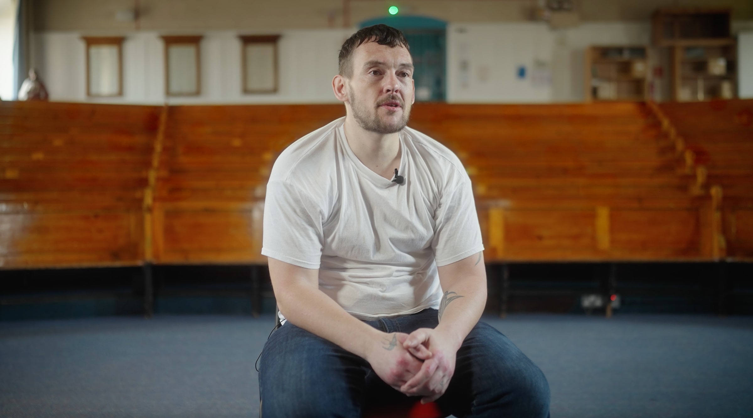 A prisoner sits in a chair as part of a talking-head interview for the documentary Served