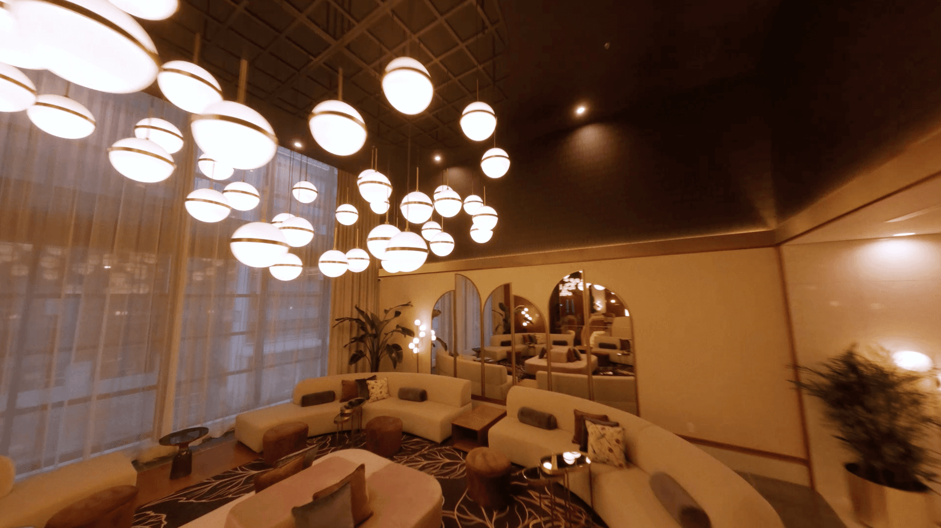 the seats are in a hotel with sofas and low-hanging lamps