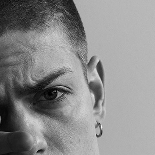 Black and white close-up of a person’s face with a serious expression, showing one eye and eyebrow in sharp detail.