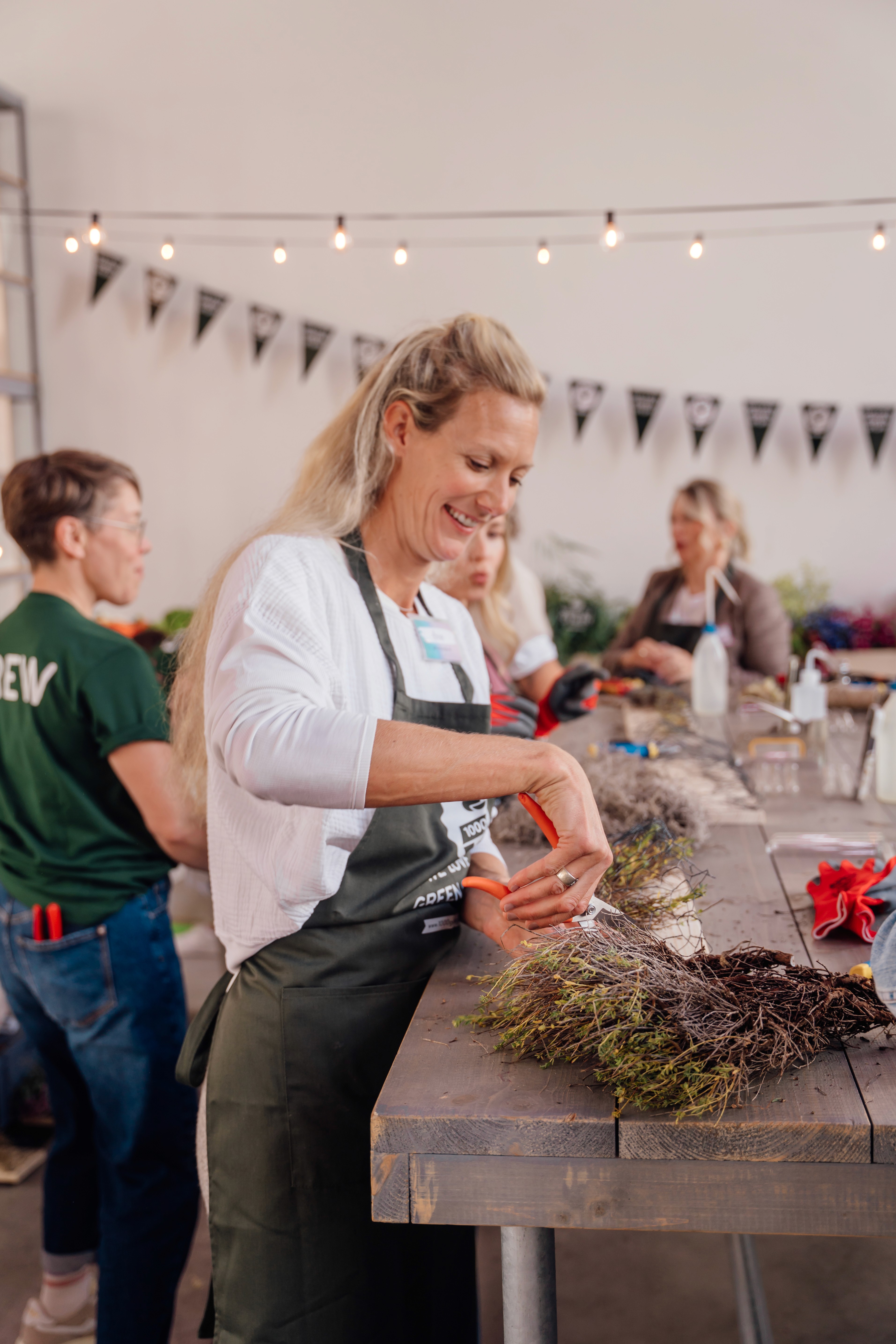 Teilnehmerin gestaltet ein florales Bouquet beim Workshop von 1000 gute Gründe.