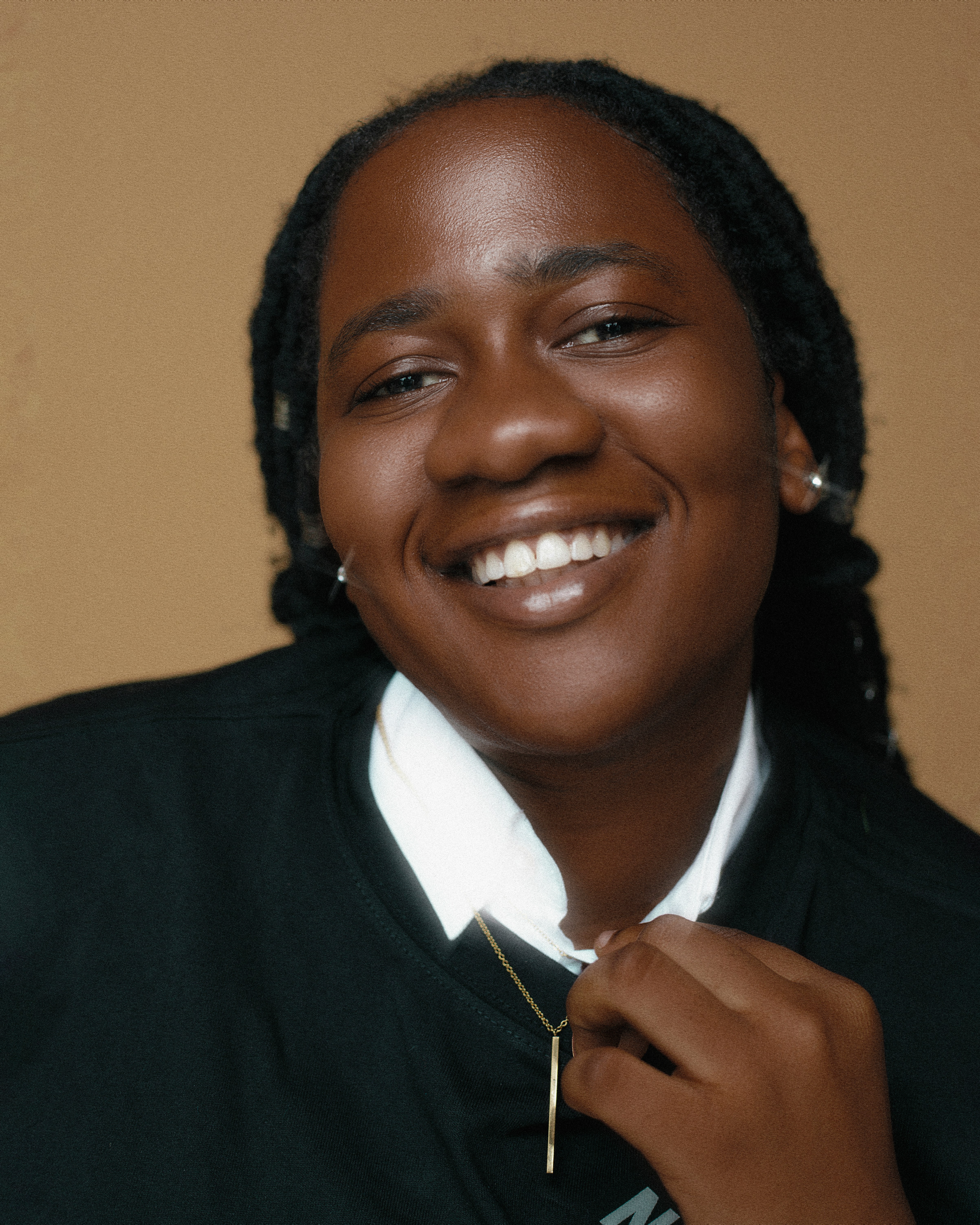 a woman smiling and wearing a white shirt