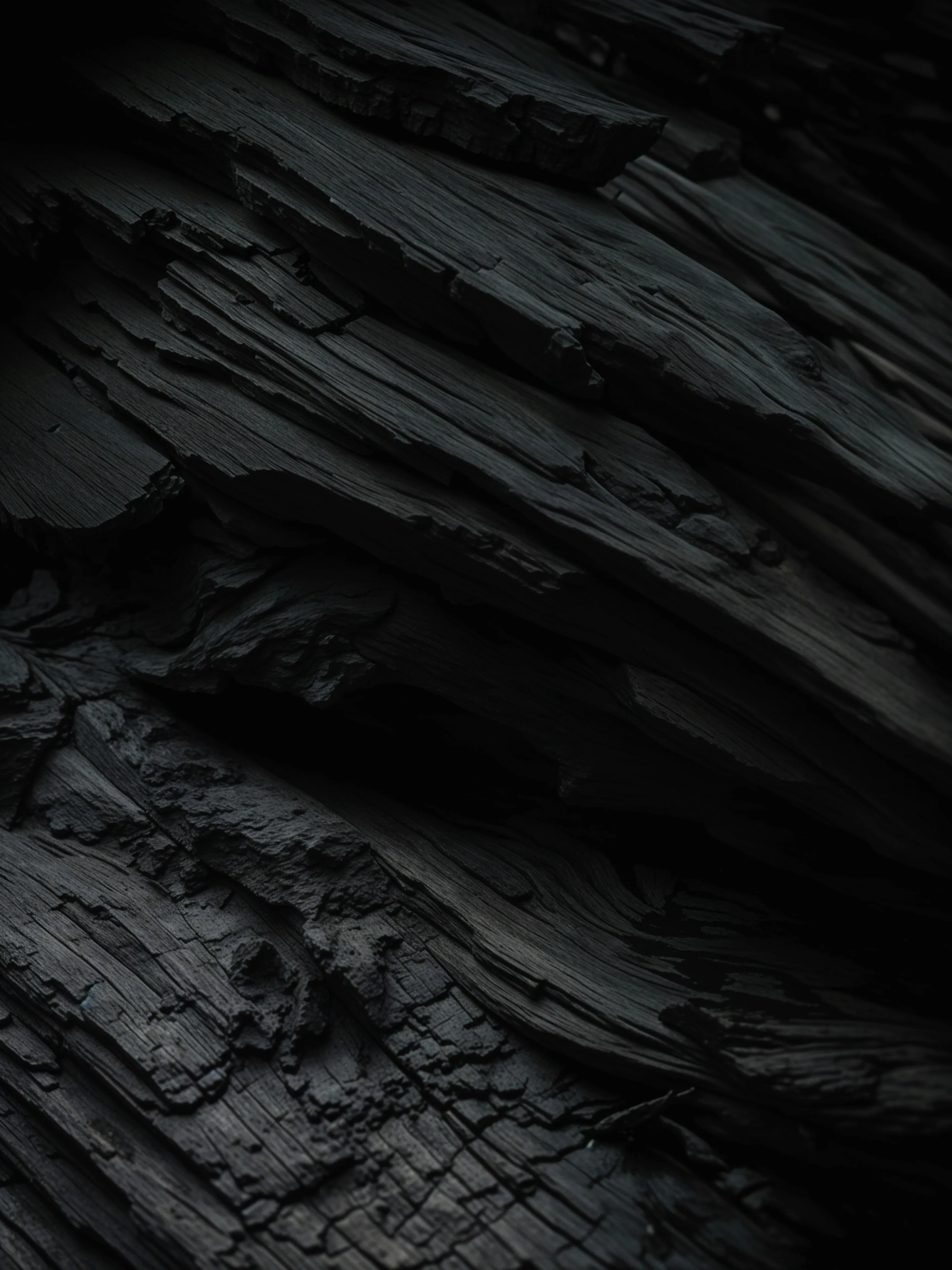 Close-up of dark charcoal with deep ridges and a rough textured surface