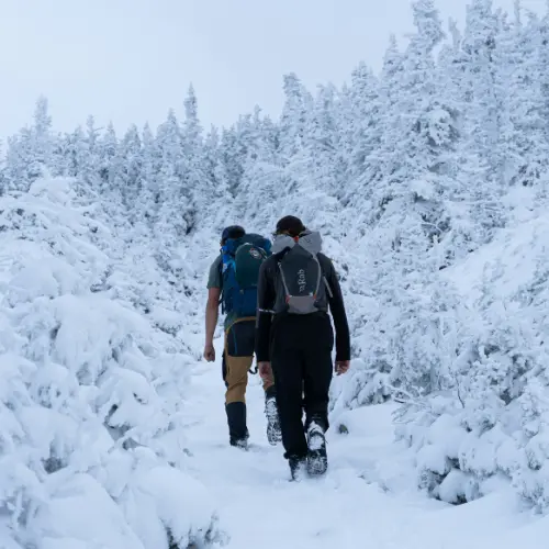 Trekking invernale in montagna con abbigliamento outdoor adeguato durante un corso di sopravvivenza