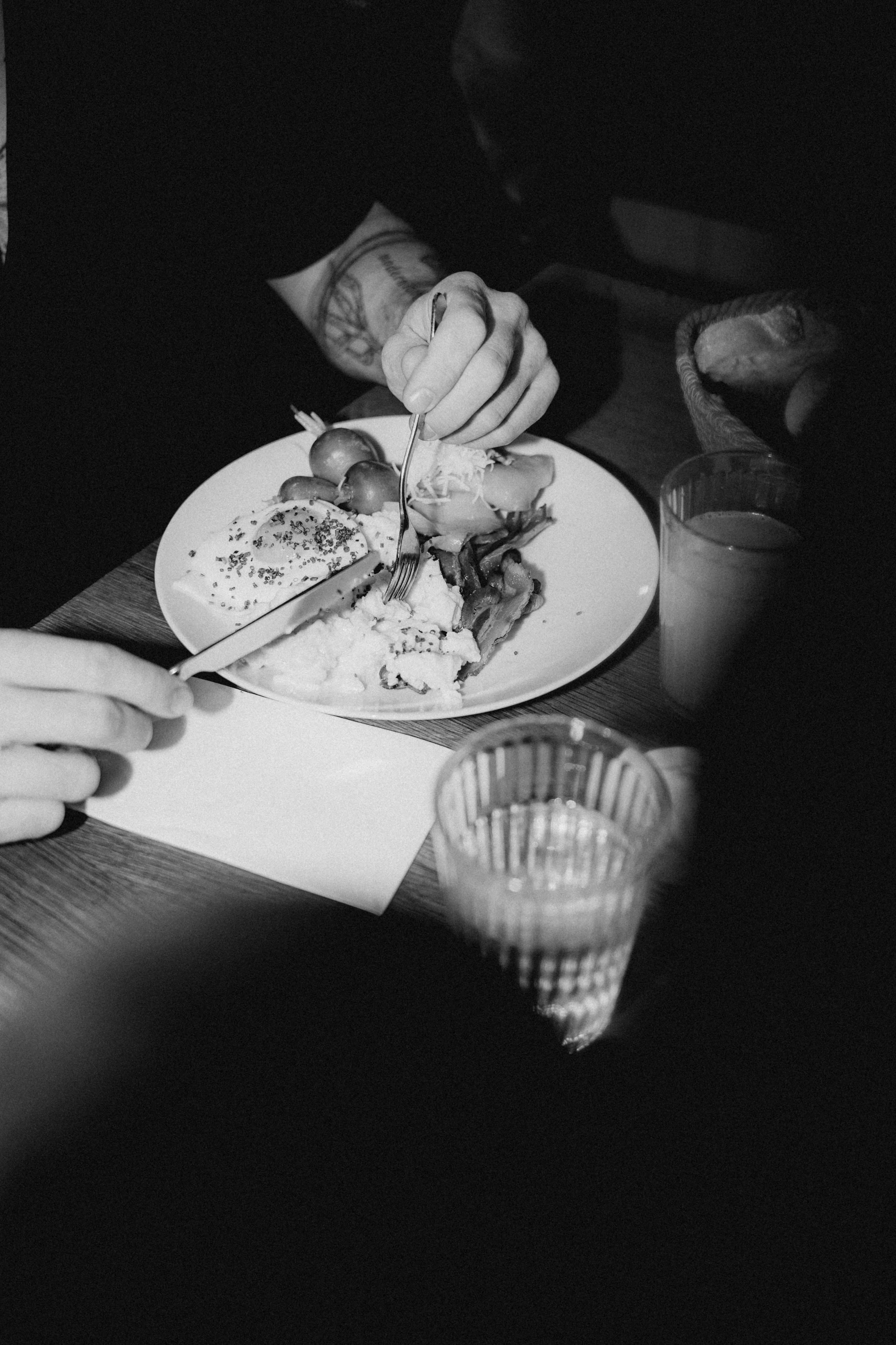 A close-up of a hand holding a plate of food, with a person's face partially visible in the background.