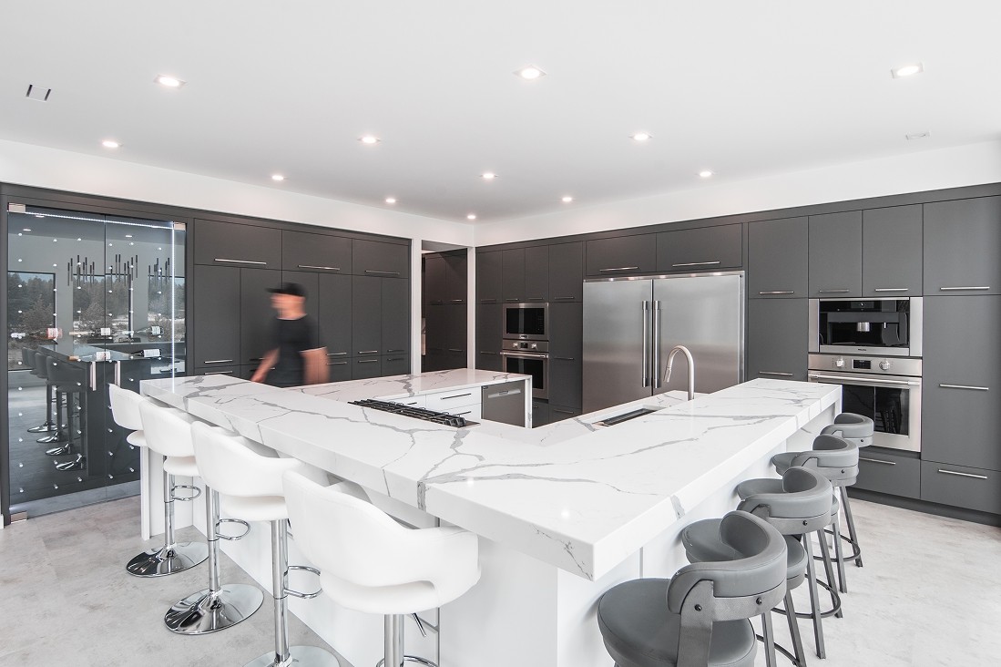 Open-concept white kitchen with island and bar stools