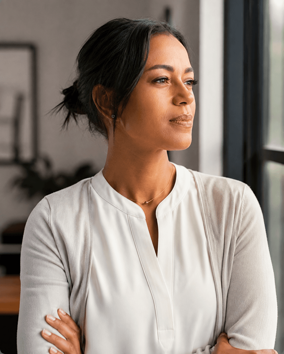 Senior professional woman in a suit looking thoughtfully from a window