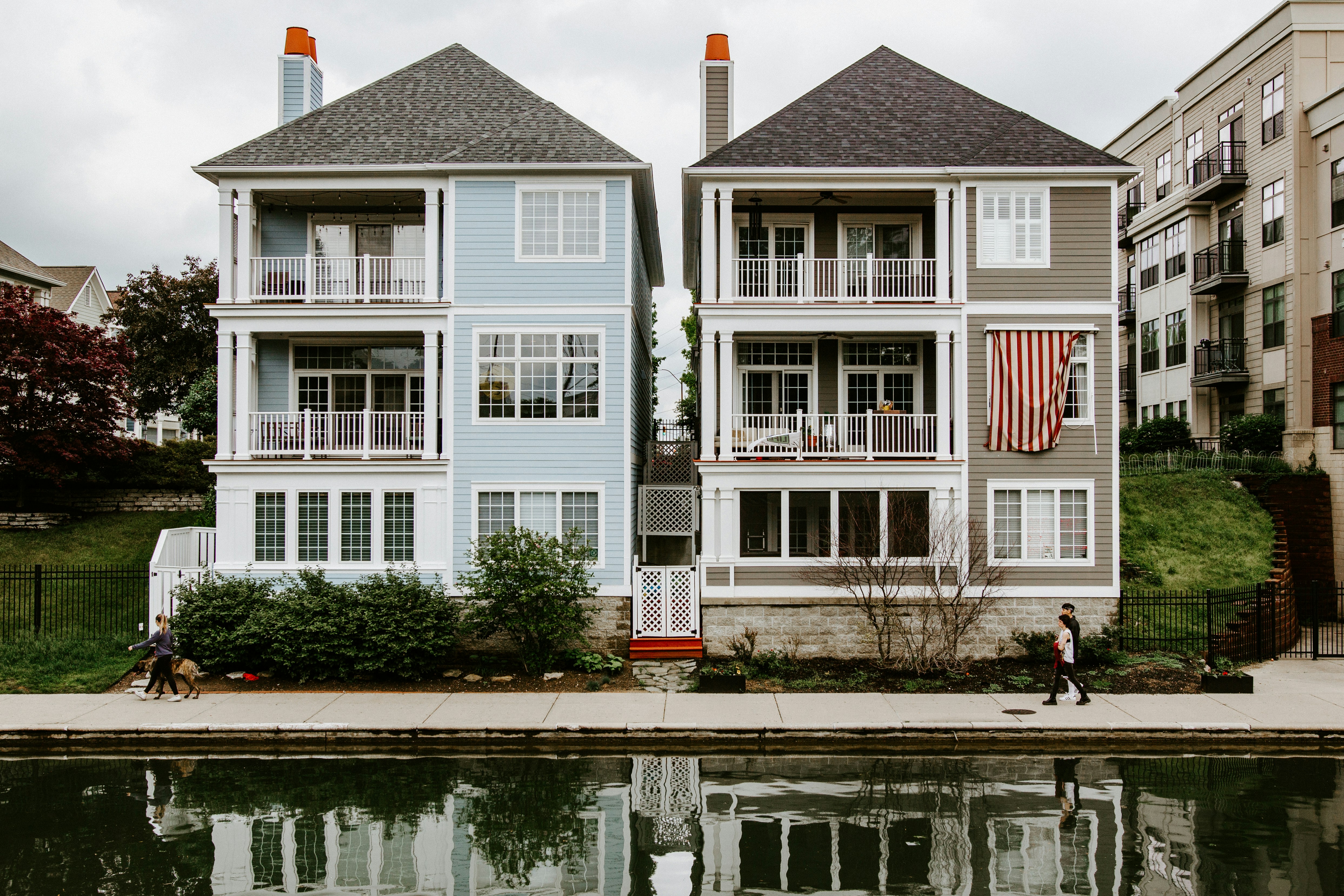 white and brown concrete house near body of water during daytime