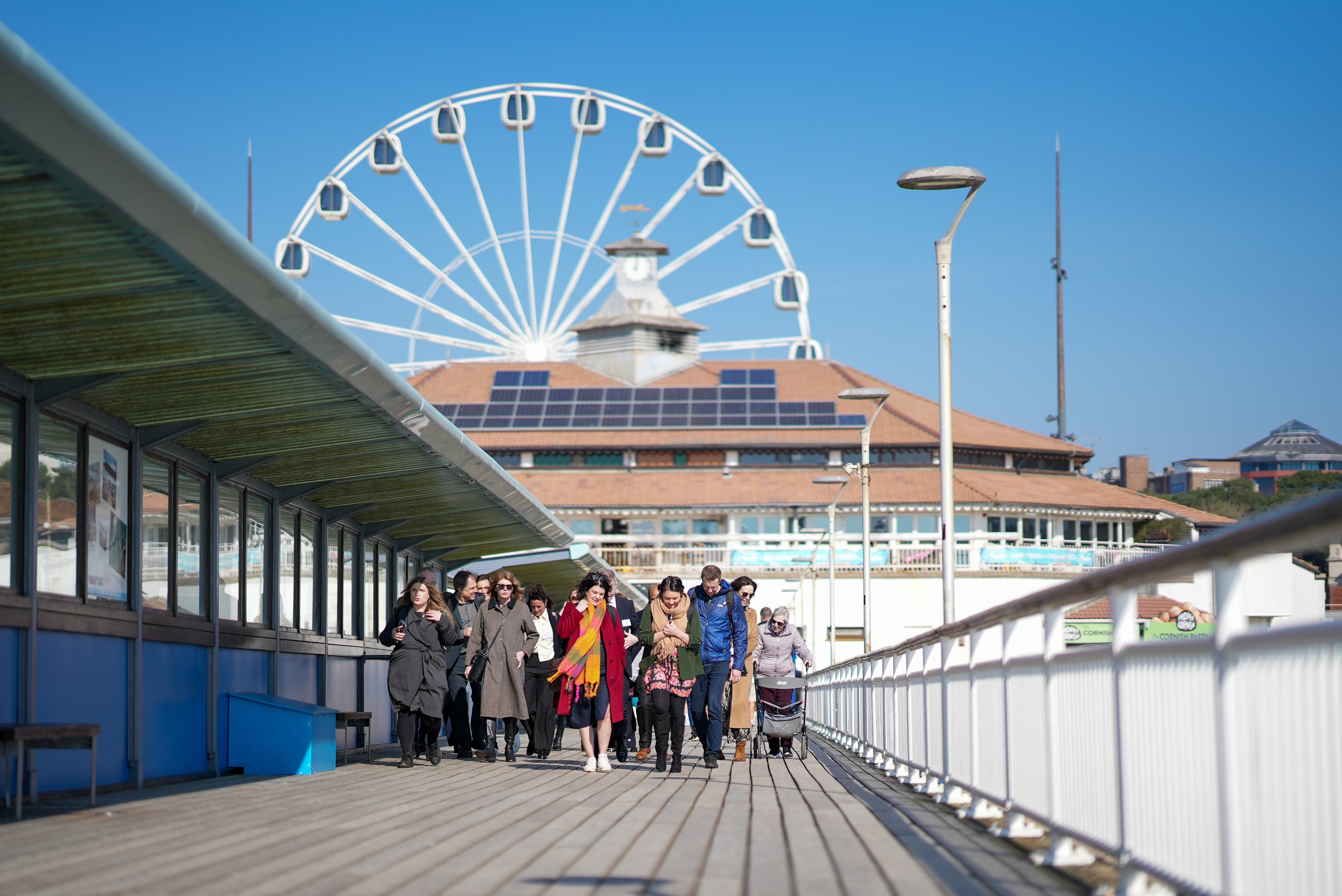 A man hands another man a microphone at an event at the City of London school