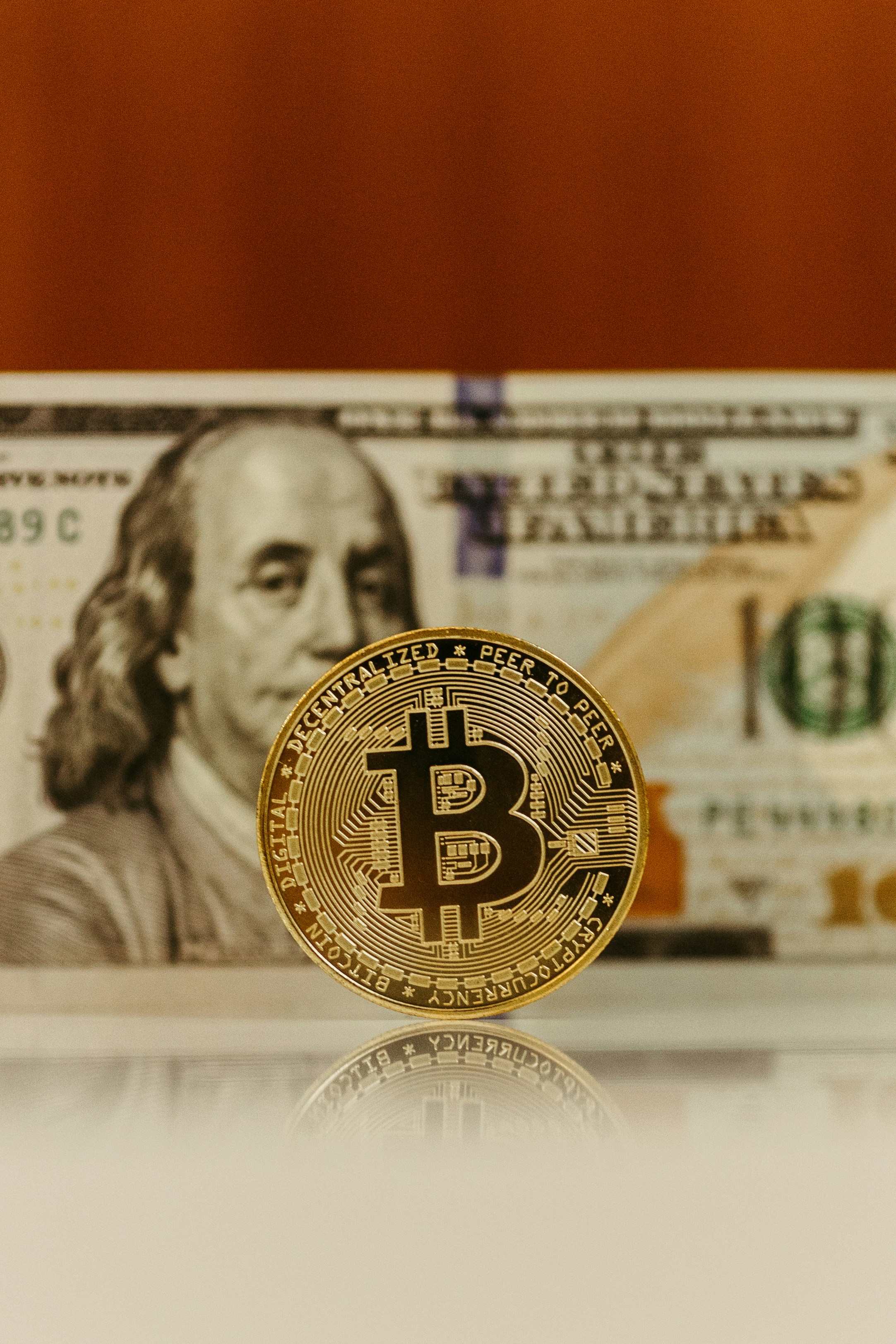 a bitcoin sitting on top of a stack of money