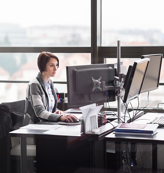 two female medical coders, one brunette and one blonde, working at computer monitors
