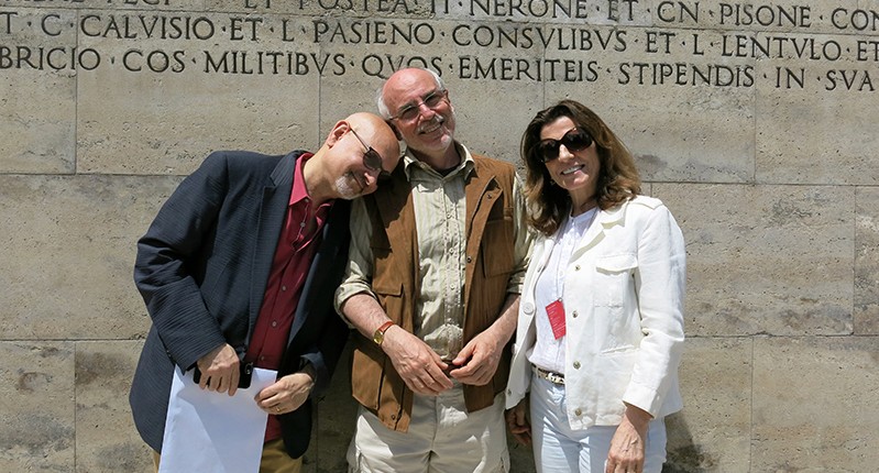 two men and a woman in front of wall
