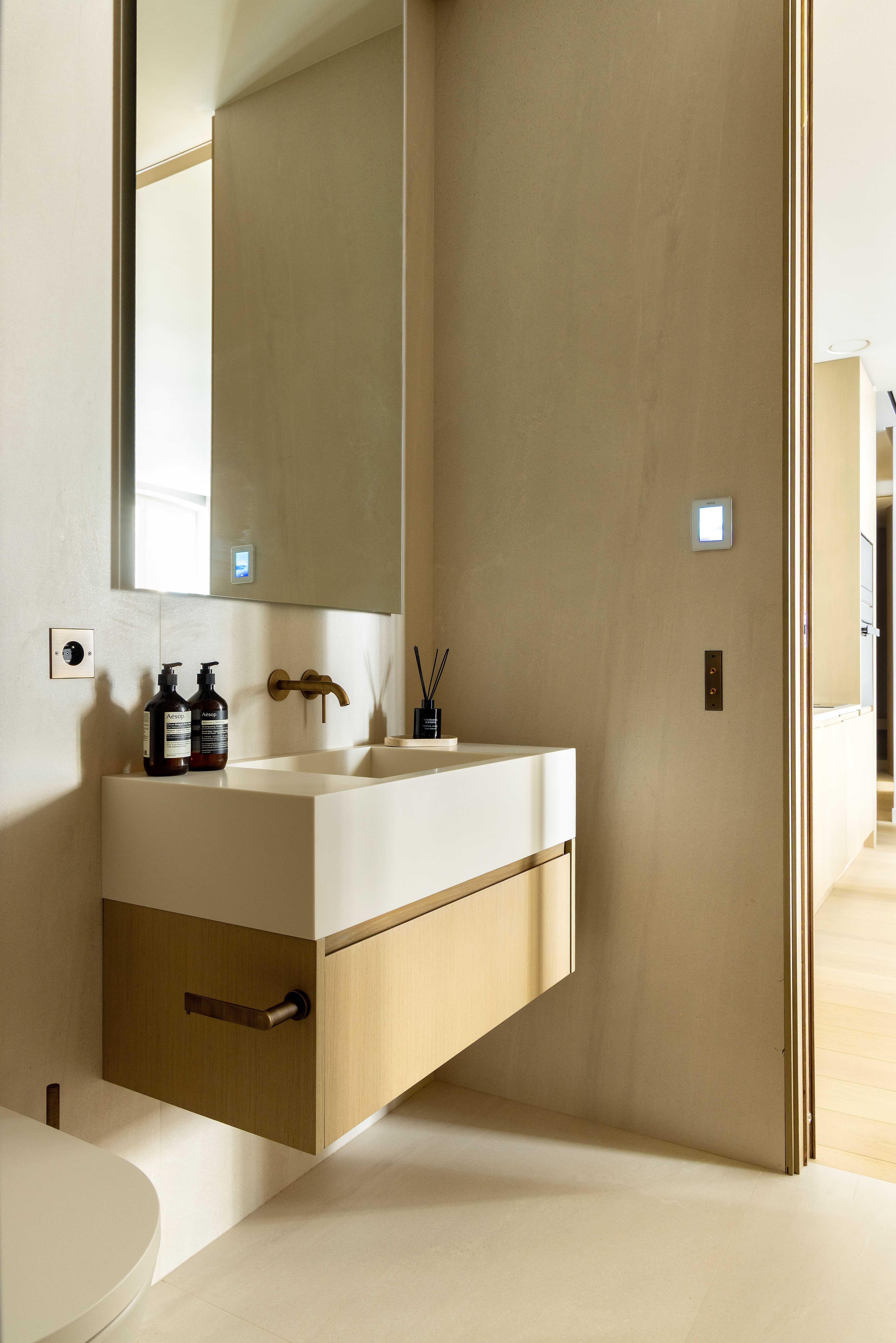 Seconde salle de bain avec vasque suspendue, grand miroir et mur en teinte sable