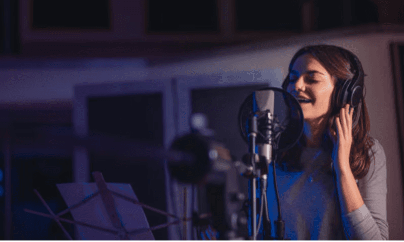 Woman singing into a mic in a studio