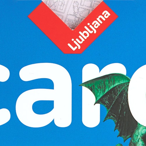 Close-up of a blue book cover with the word "Ljubljana" in white text and an illustration of a green dragon's wing.