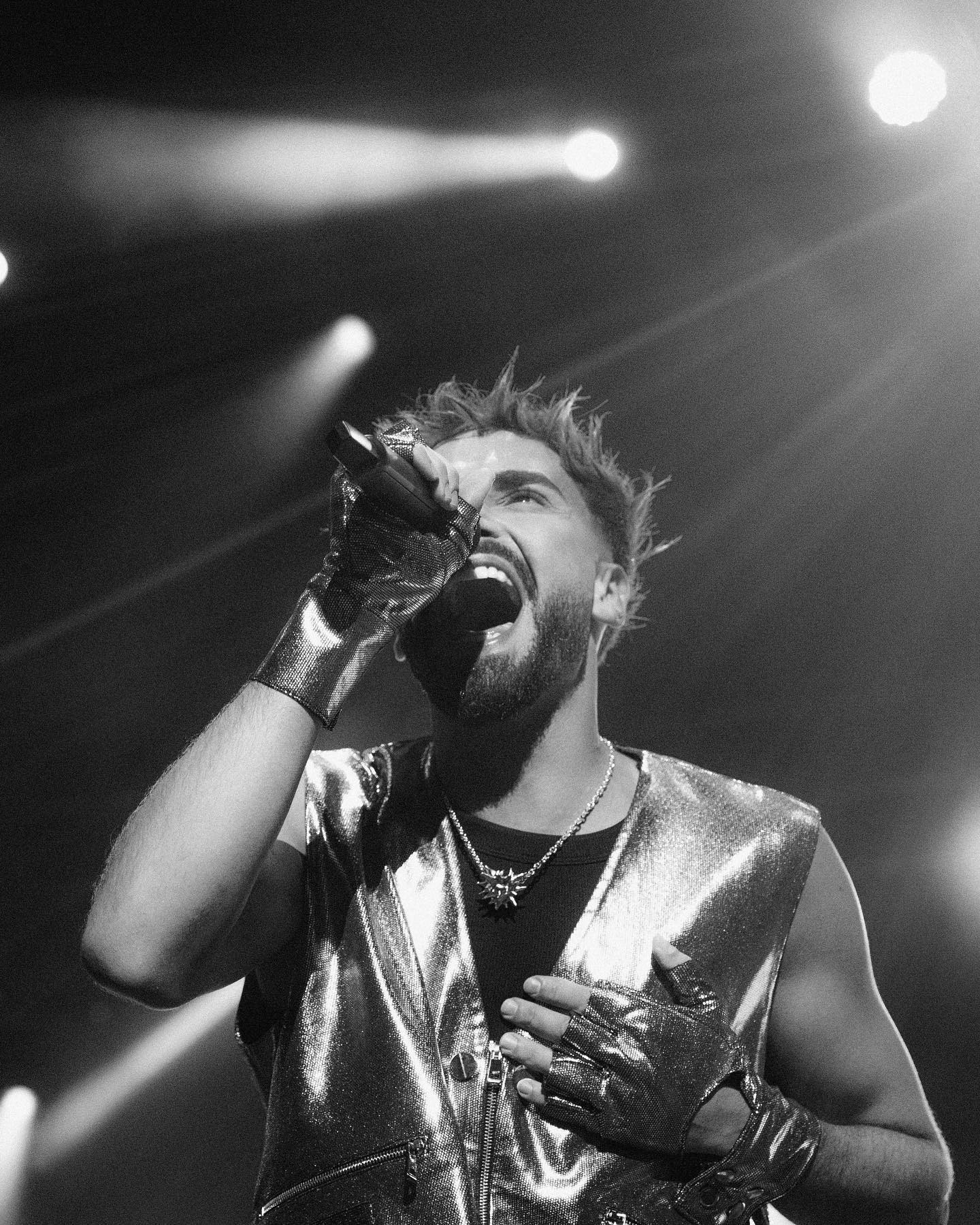 person discussing while standing in front of a large screen in front of people inside dim-lighted room