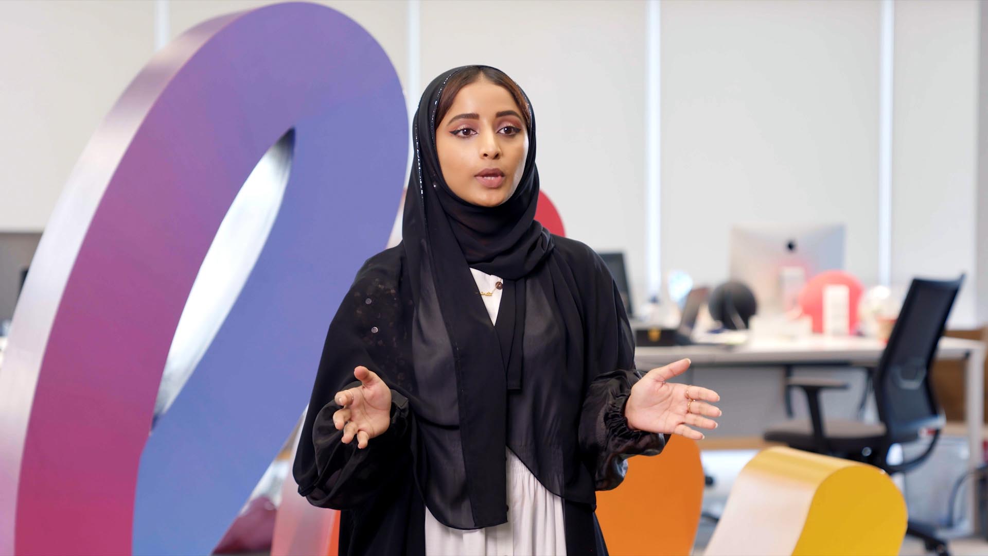 Young emirati woman speaking in office environment 