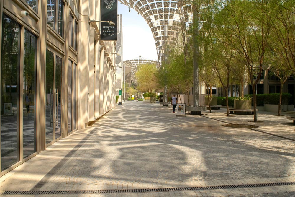 Expo City Dubai, featuring a blend of trees and modern buildings, showcases a vibrant urban landscape.