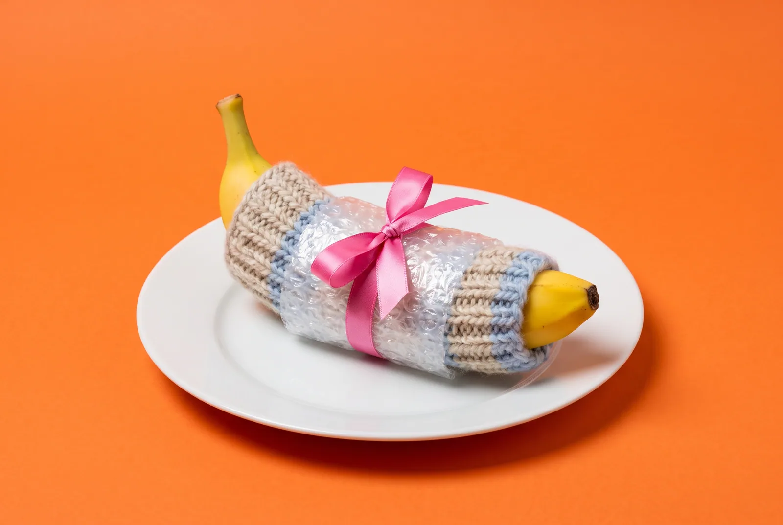 A banana wrapped in a knit sleeve, bubble wrap and ribbon, layering filters to block porn on your router and devices
