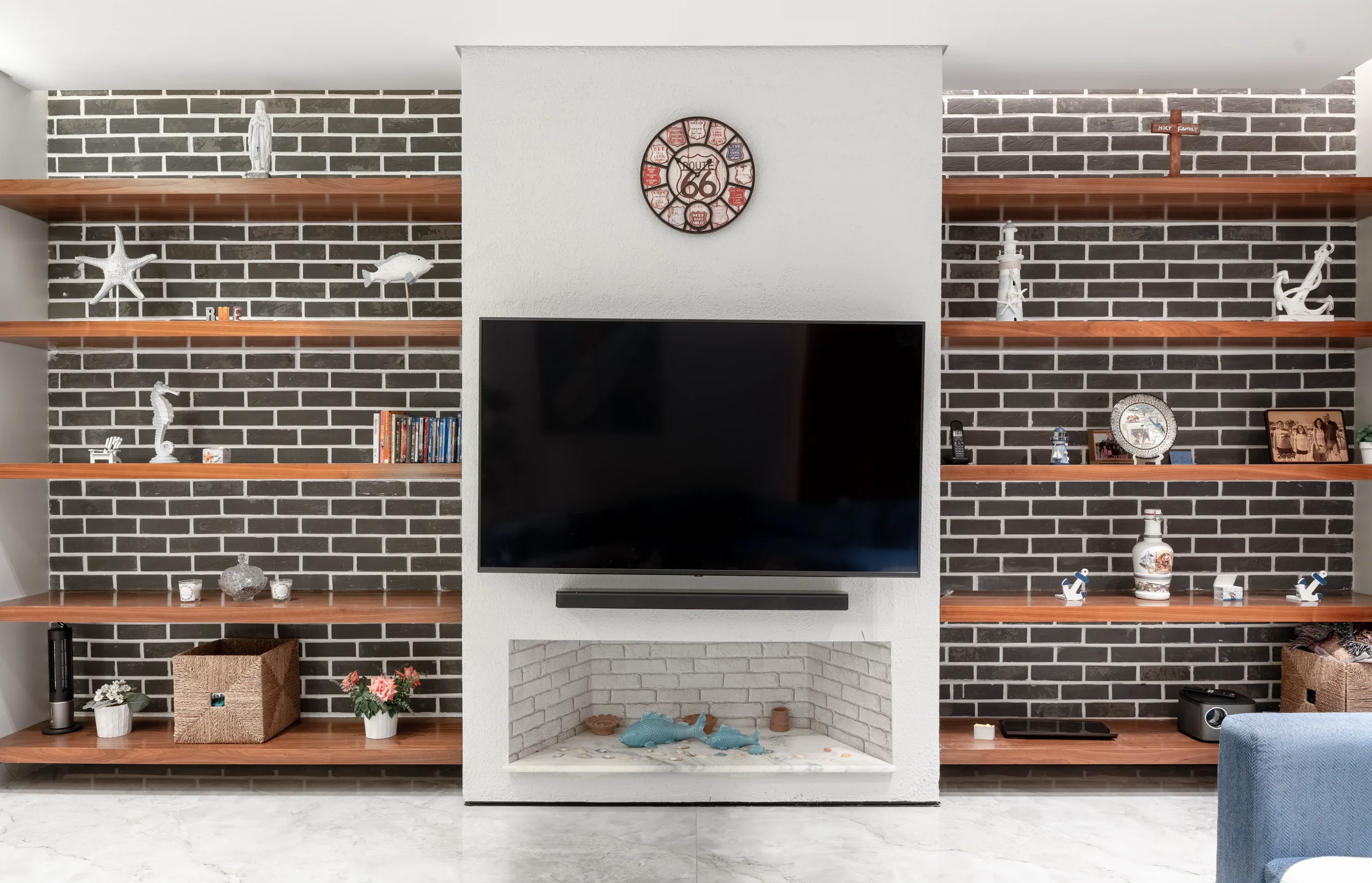 Custom television and brick-clad feature wall in the Caesar SODIC Villa living room.