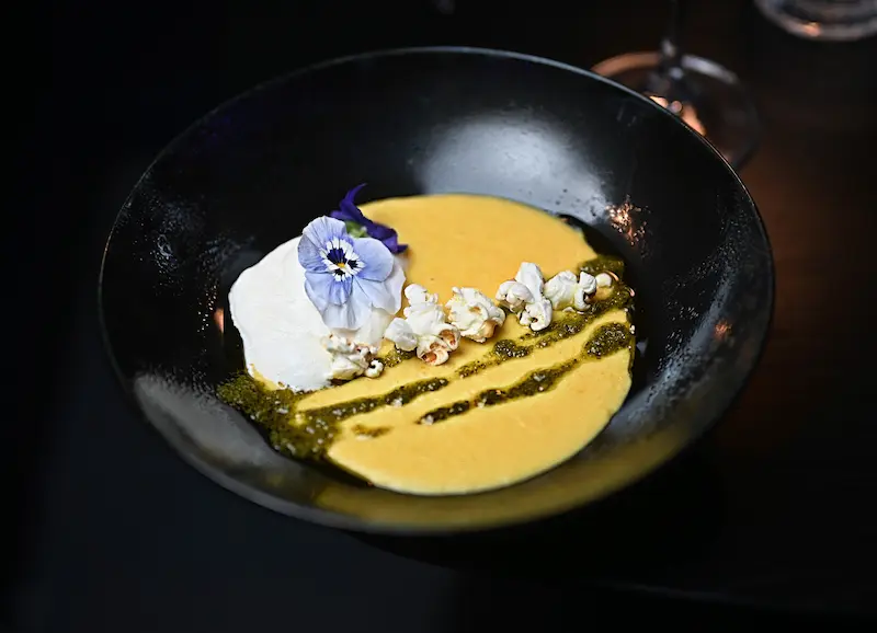 A beautifully presented gourmet dish with edible flowers, served on a restaurant table