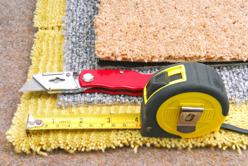 stacks of carpet, carpet knife, measuring tape 