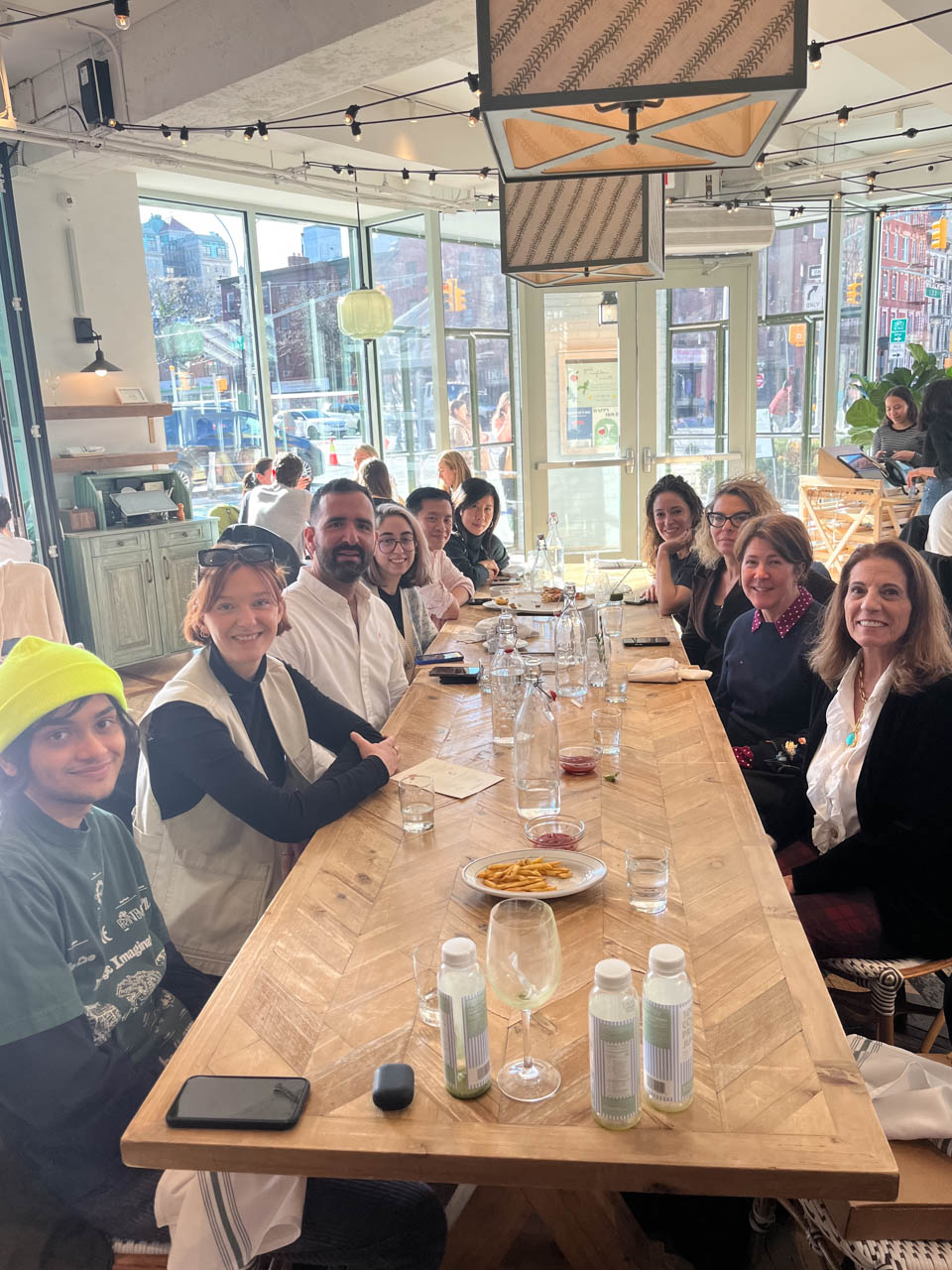 group photo of many people at a restaurant table