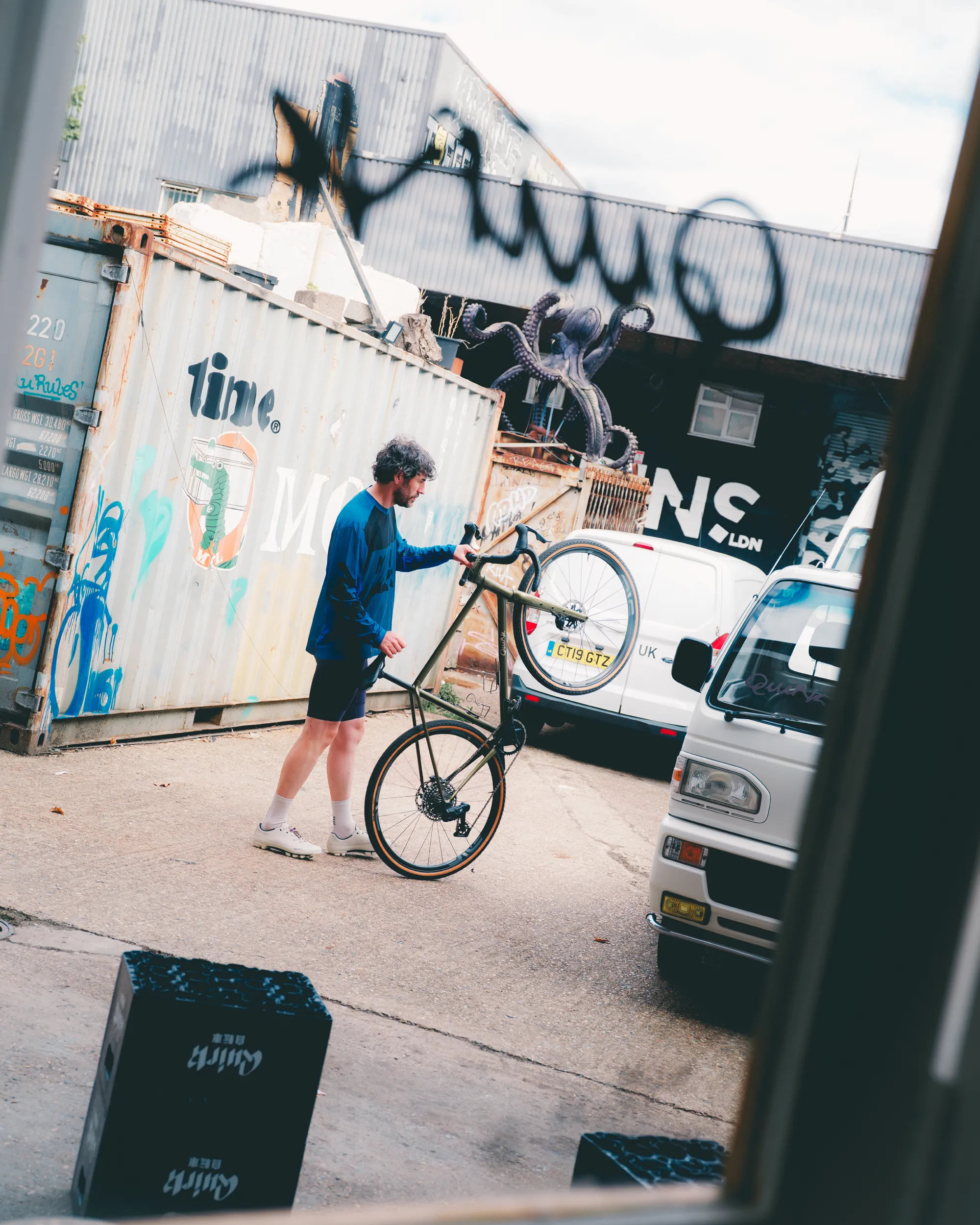 Light blue Quirk Cycles Durmitor road bike in a workshop with dark wheels