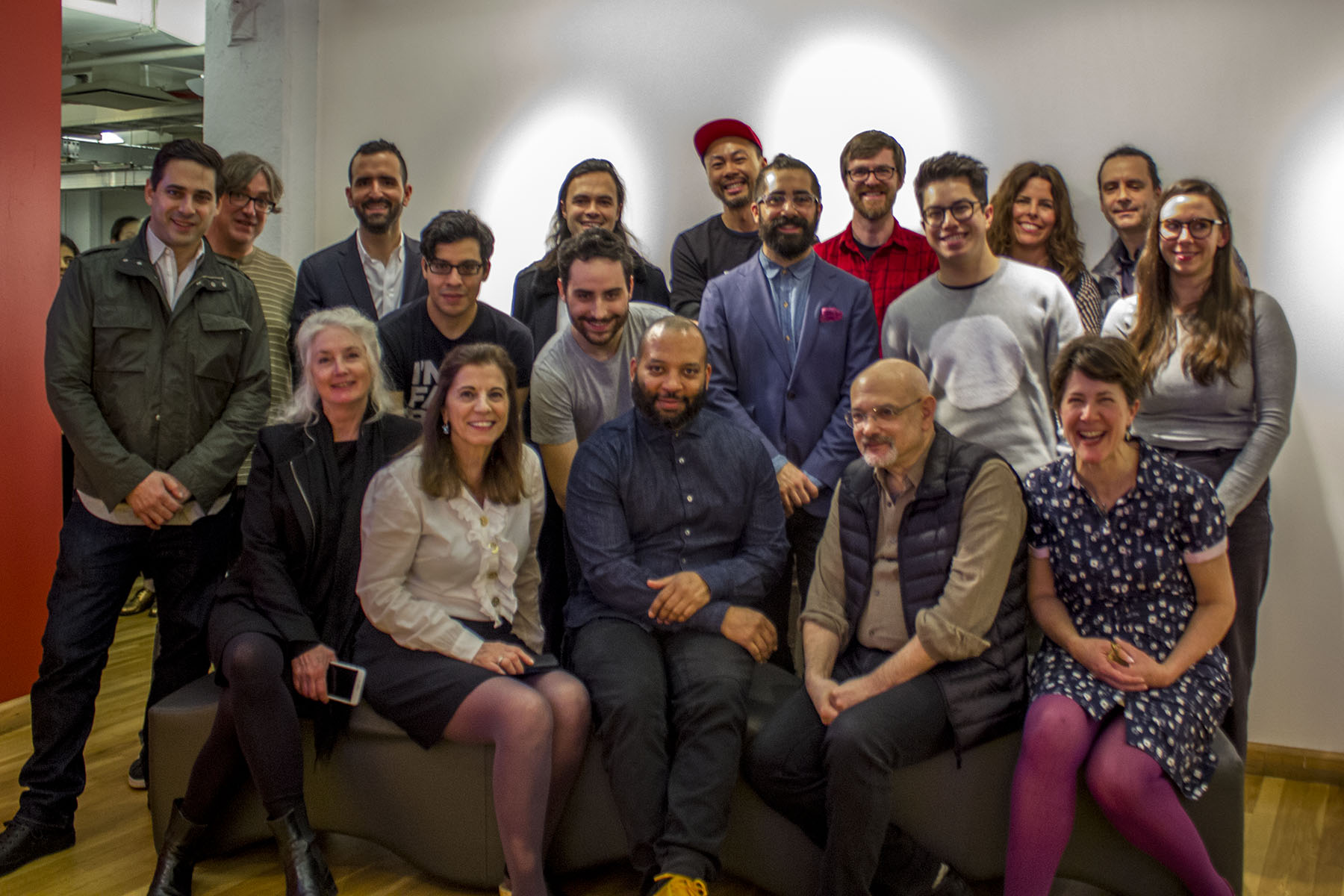 A photo of a group of people sitting in a exhibition room.