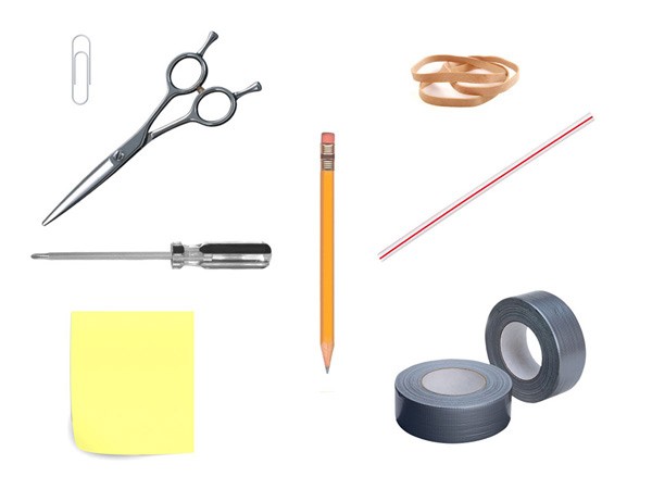 A pair of silver-handled scissors with open blades is positioned in the top left corner. Below it, a yellow sticky note is placed. To the right of the note, a screwdriver with a black handle is positioned horizontally. Above the screwdriver, a pencil with an orange eraser is visible. In the top right corner, two rubber bands are placed side by side. Below them, two rolls of gray tape are positioned side by side. The background is white.