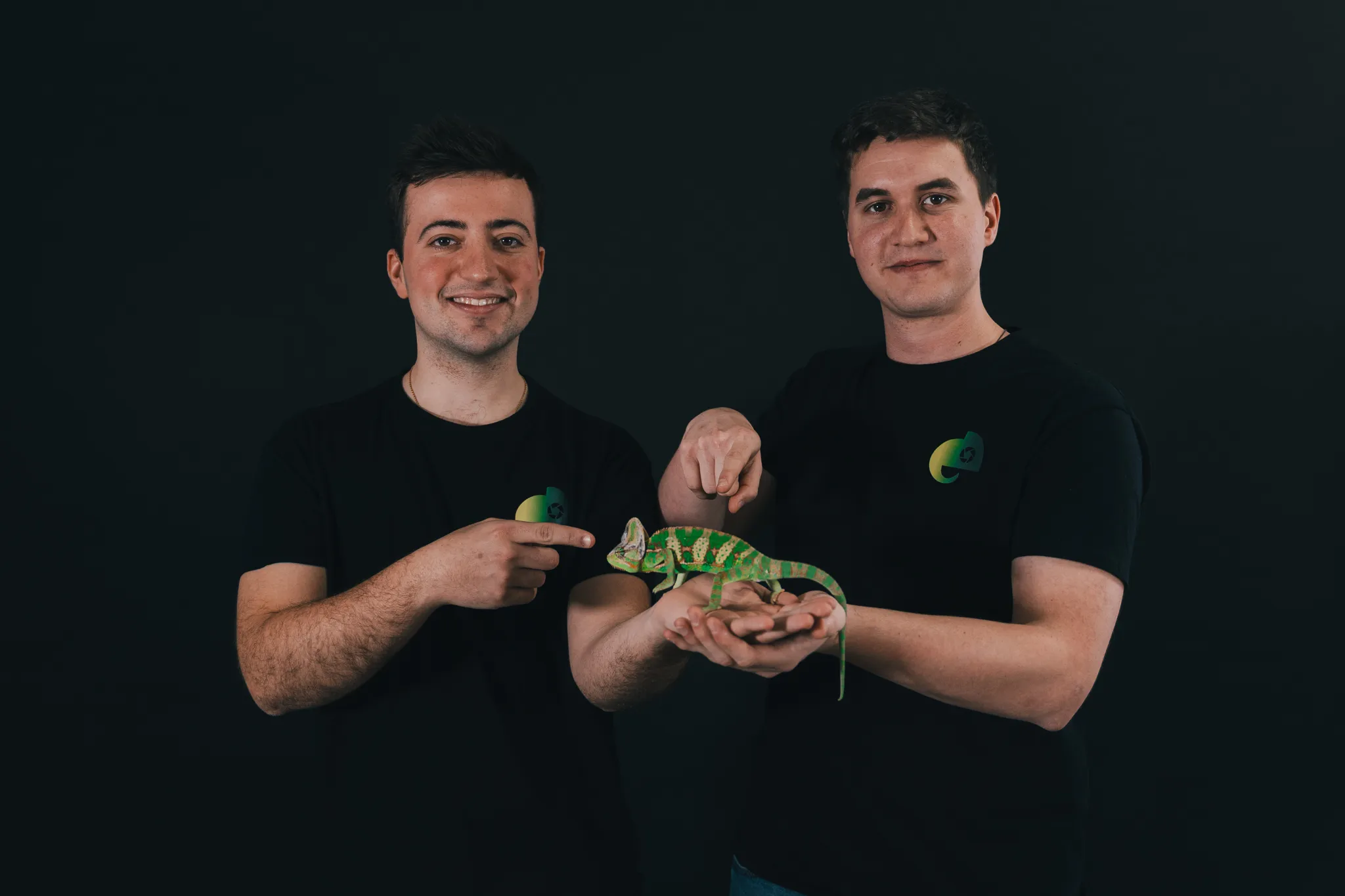 A woman stands beside an old projector, gazing at the camera. The scene is lit with teal and red hues, creating a mysterious and artistic atmosphere.