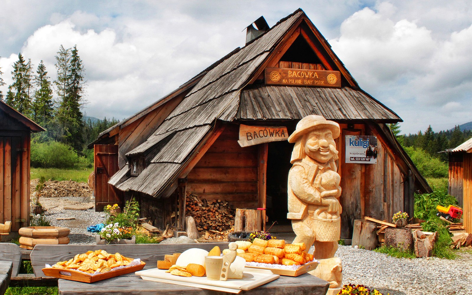 Wooden hut in Zakopane with traditional cheese display and carved figure.