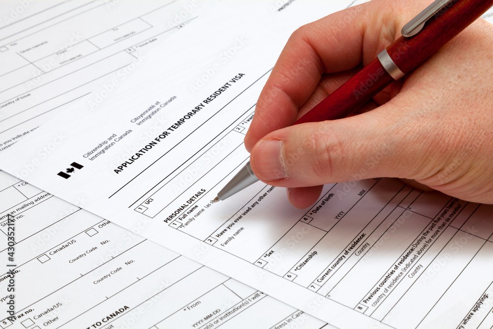 a wooden table topped with papers and a pen