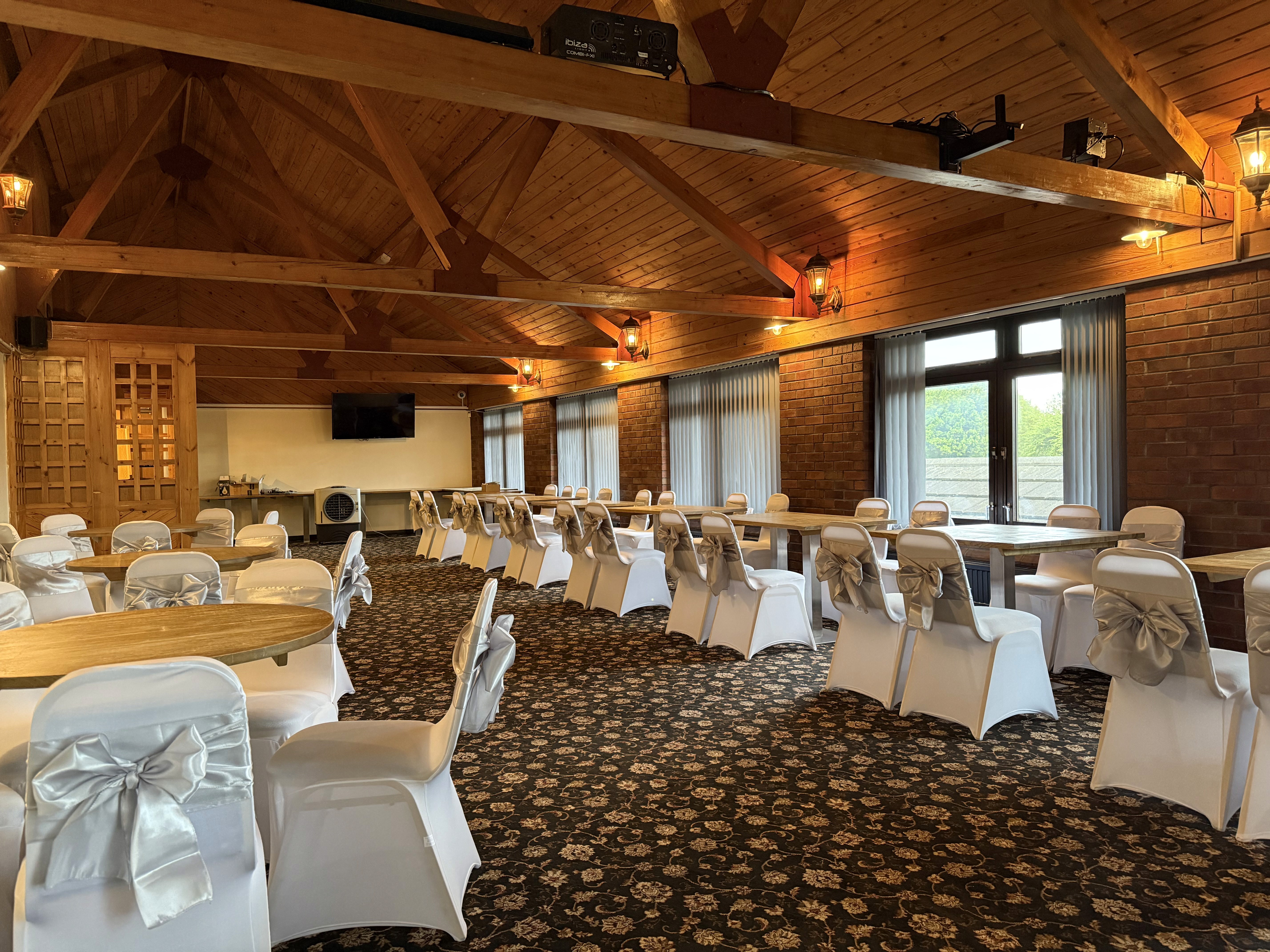 Large function room with open ceiling and furniture