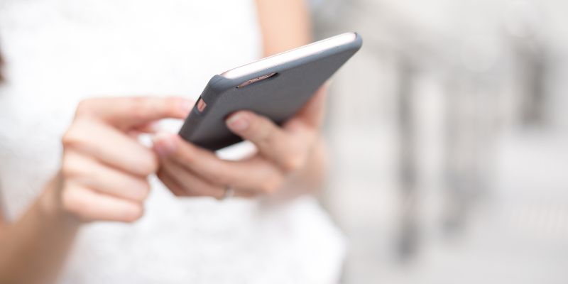 A woman typing on her phone