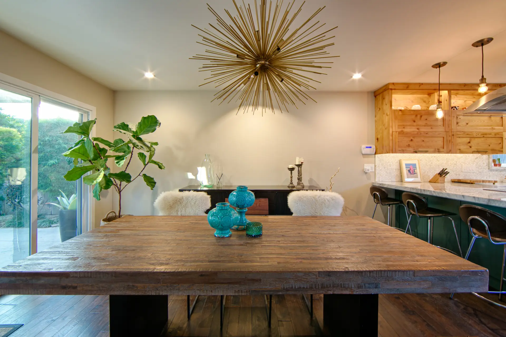 Dining space with large wooden table and starburst light fixture in Huntington Beach & Bath Kitchen Remodel.