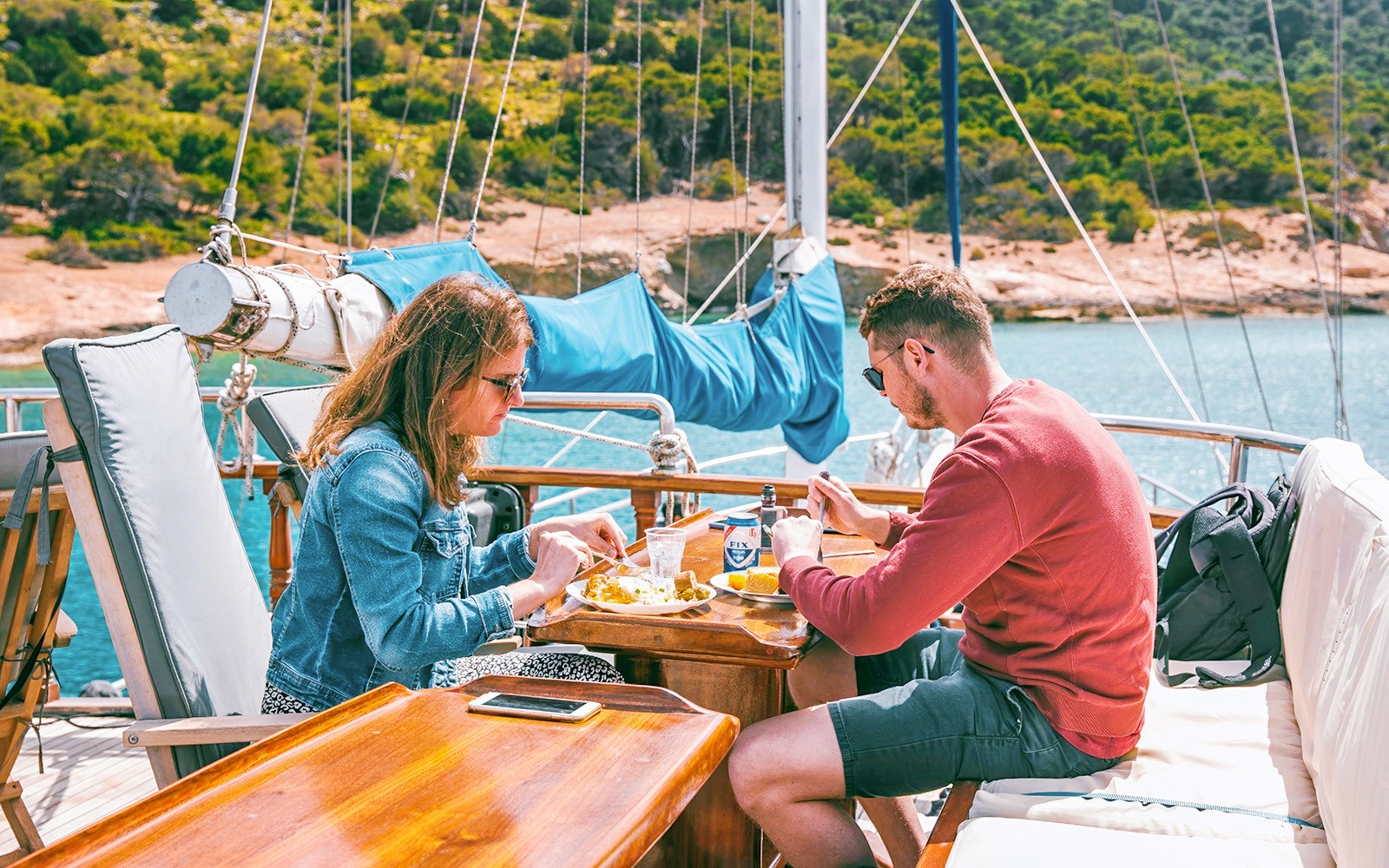 Pary cieszące się lunchem z piwem podczas rejsu w pobliżu wysp Agistri, Moni i Egina, Grecja.